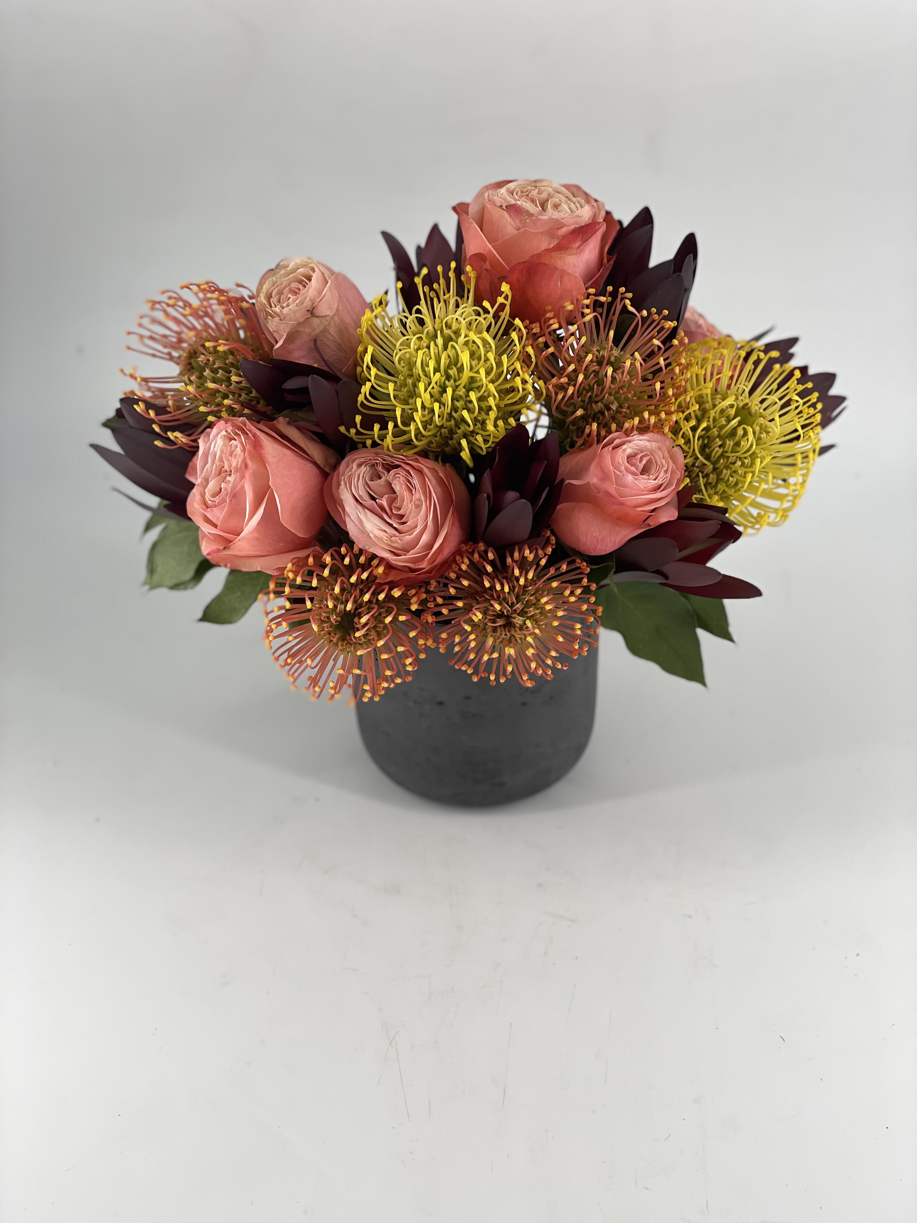 Zulu - The focal points of this unique arrangement are the varieties of Protea. Protea’s native home is South Africa, the native home of legendary Zulu tribe. Zulu’s were one of the most powerful tribes and original inhabitants of South Africa and surrounding regions. Their history as warriors and a developing civilization is well documented. The strength of these Protea varieties chant the extraordinary heritage of the Zulu people, who share their beautiful home. 