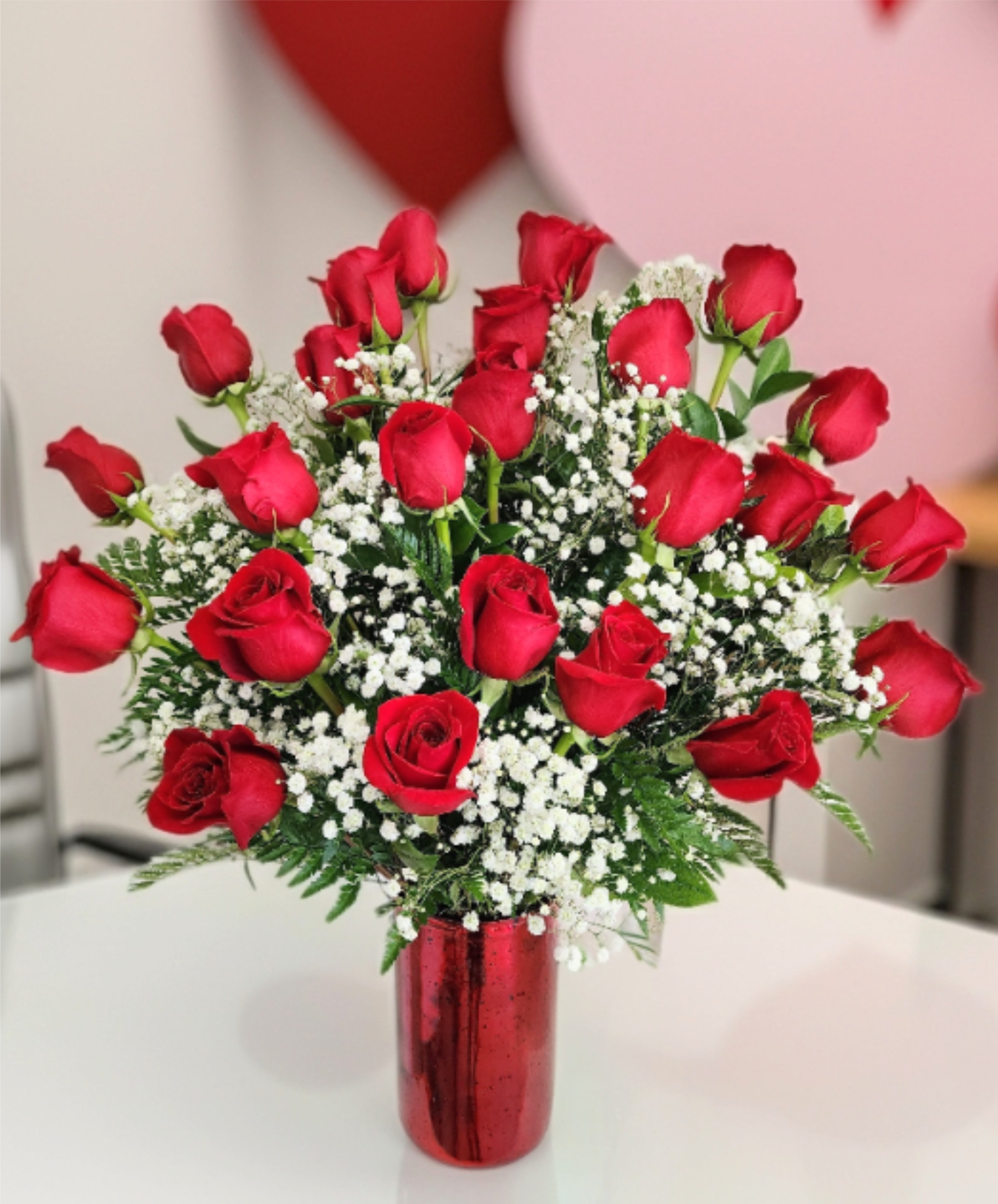 Devoted Love - 24 Red Ecuadorian long stem roses in a red shimmer vase with babies breath and greenery. 