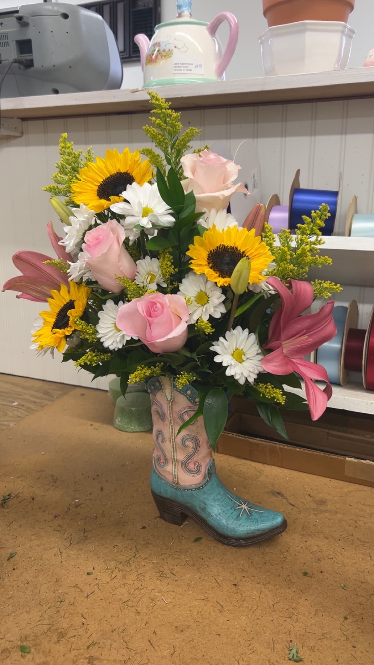Cowboy Boot Arrangment - Looking for something unique and different for that special someone? Let our designers create a one of a kind Cowboy boot arrangement for you. Each design different and unique.