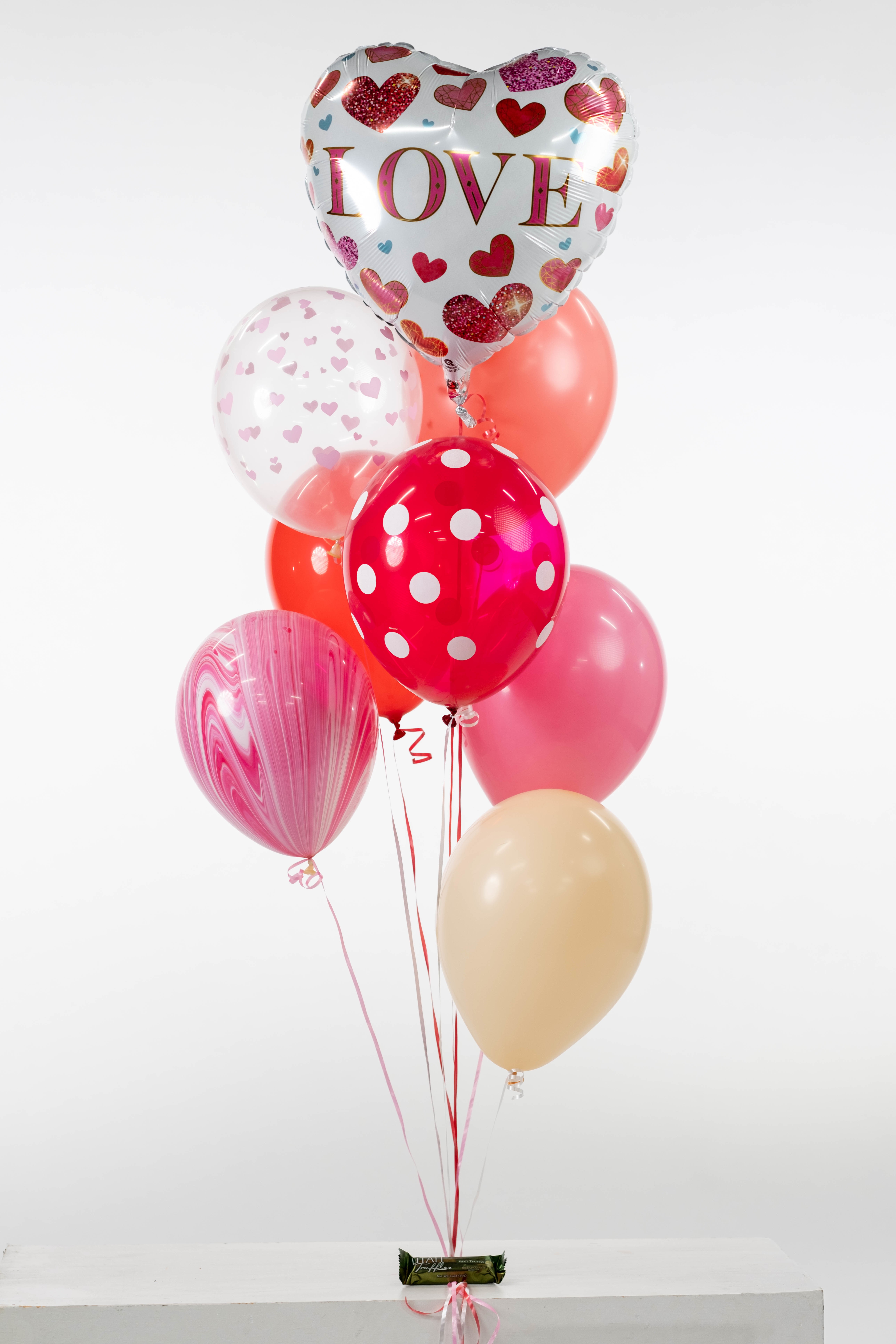 Valentine Special # 2 - Perfect for Valentine's Day 3 printed latex, 3 plain latex, 1  Valentine Mylar, 1 Utah Truffle as a balloon weight. We'll put together a fantastic grouping of various printed and plain balloons with a Mylar balloon to top it off. BALLOONS MAY LOOK DIFFERENT THAN THE ONES PICTURED. *ALL Sales are Final we cannot guarantee balloons due to varying weather conditions and the nature of the balloon*