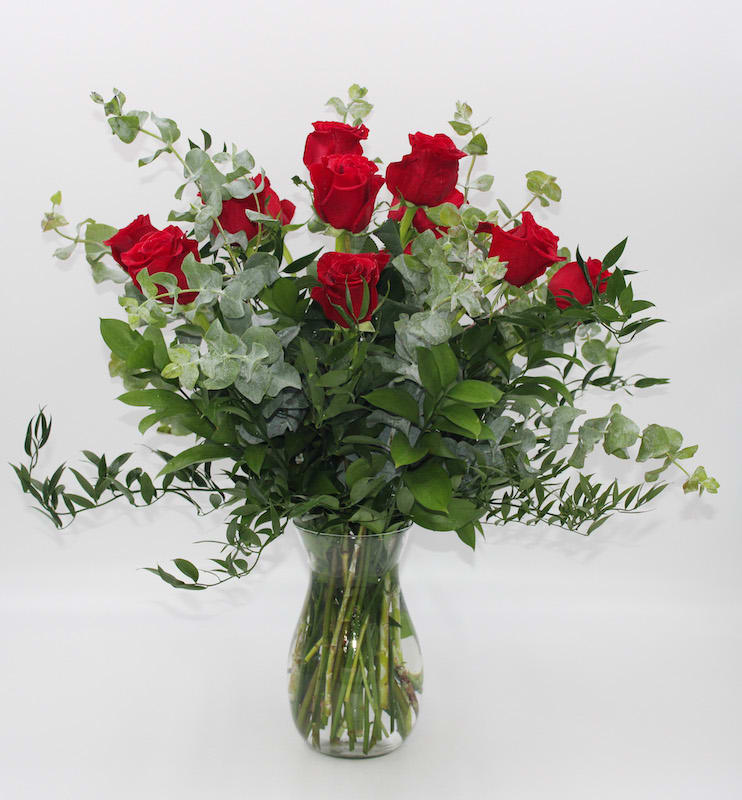 One Dozen Red - A Classic one dozen Ecuadorian Long Stem Red Roses with upscale greens such as Ruscus and Eucalyptus and a clear glass vase and is pictured. 