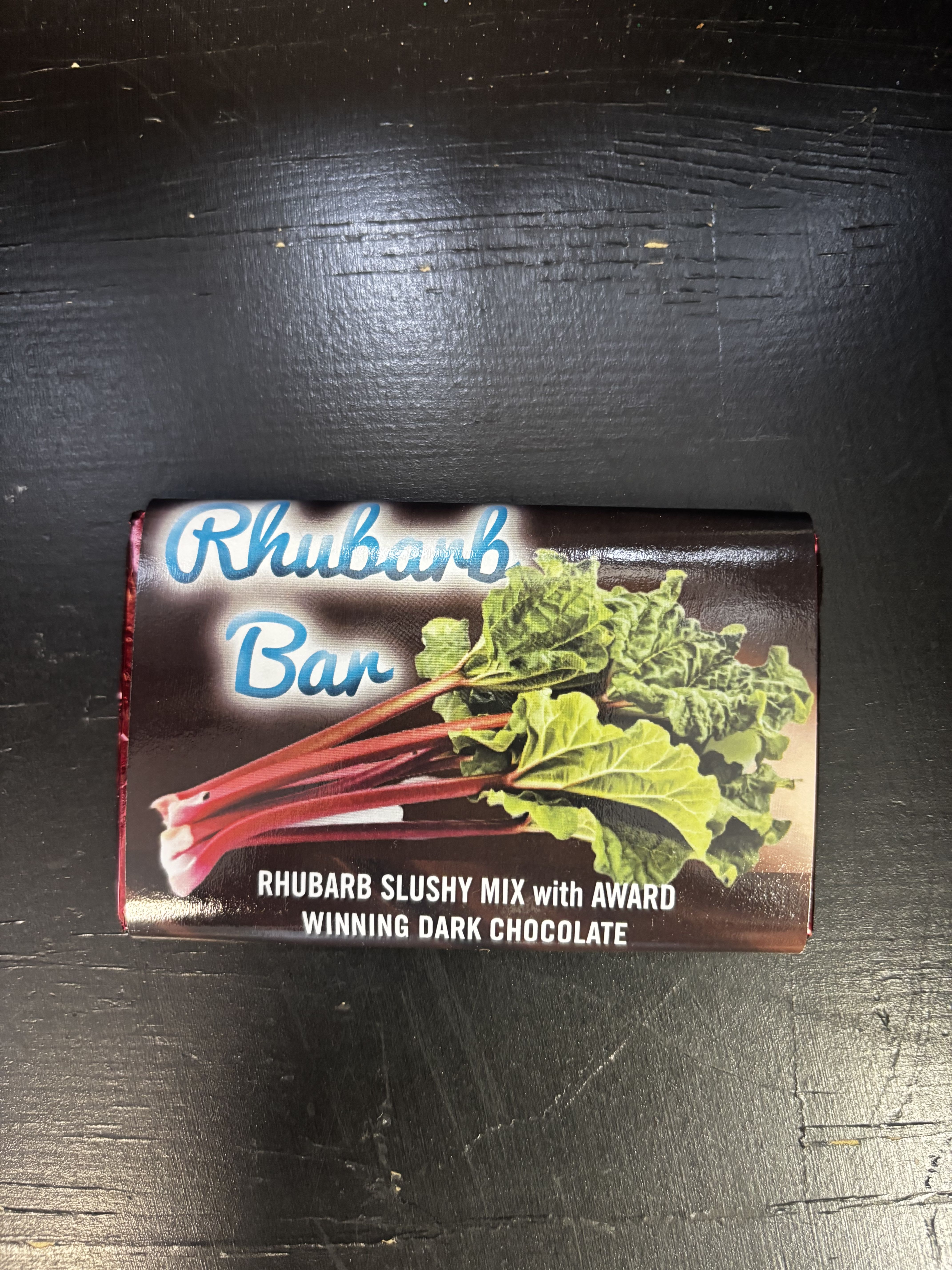 Rhubarb Bar -Dark Chocolate  - A delightful blend of sweet-tart rhubarb and rich, award-winning dark chocolate. This unique bar pairs the bright, nostalgic flavor of rhubarb slushy mix with smooth, decadent chocolate for a perfectly balanced treat. A must-try for rhubarb lovers and anyone who enjoys a bold, unexpected chocolate experience.