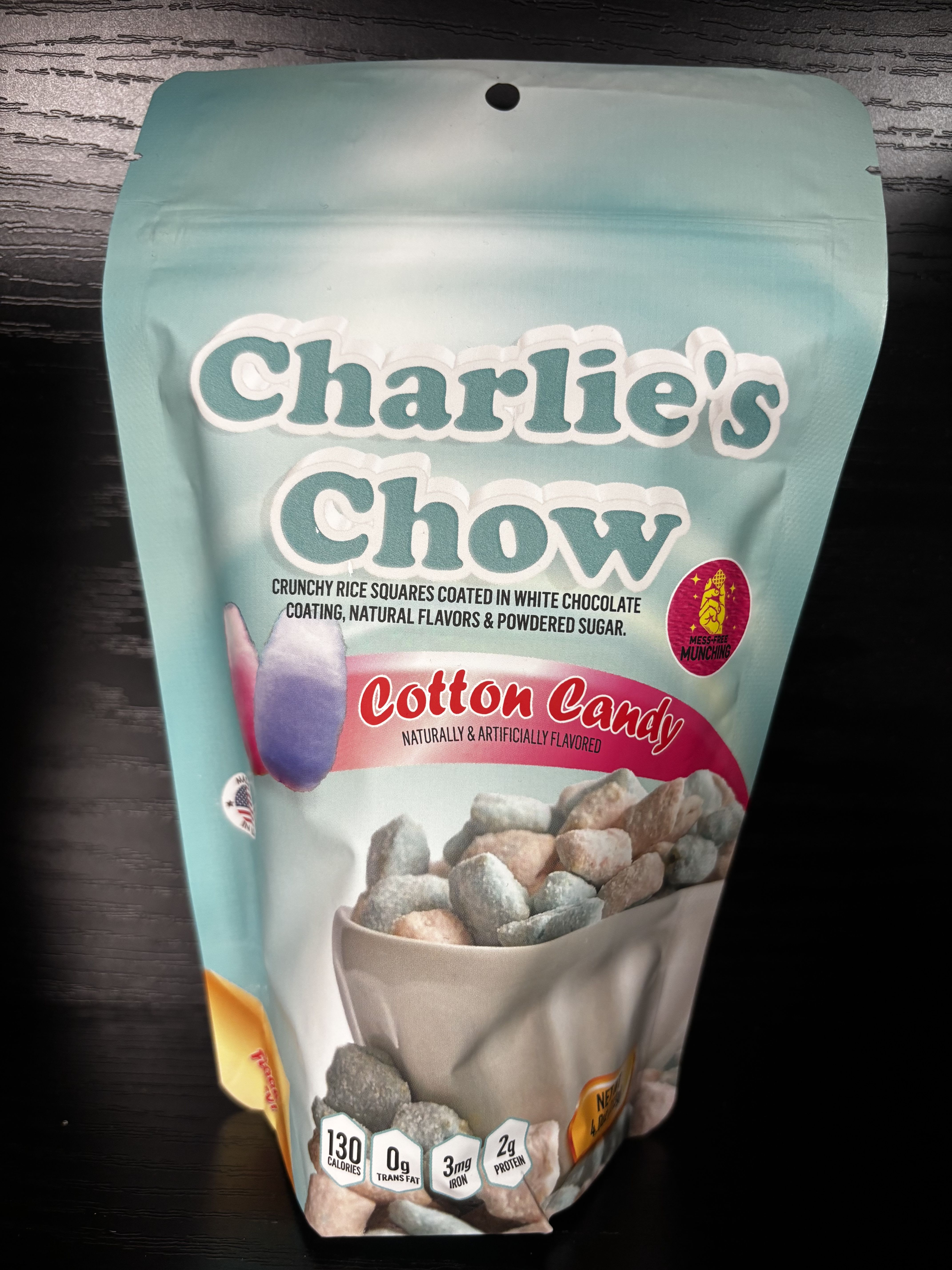 Charlie’s Chow – Cotton Candy - Sweet, fluffy fun in every bite! Charlie’s Chow Cotton Candy takes crunchy rice squares and coats them in creamy white chocolate, then dusts them with powdered sugar and a nostalgic cotton candy flavor. Light, colorful, and delightfully sweet, this playful treat is perfect for kids, parties, gift baskets, or anyone who loves a throwback carnival-style snack. A cheerful, eye-catching favorite that’s just as fun to eat as it is to gift.