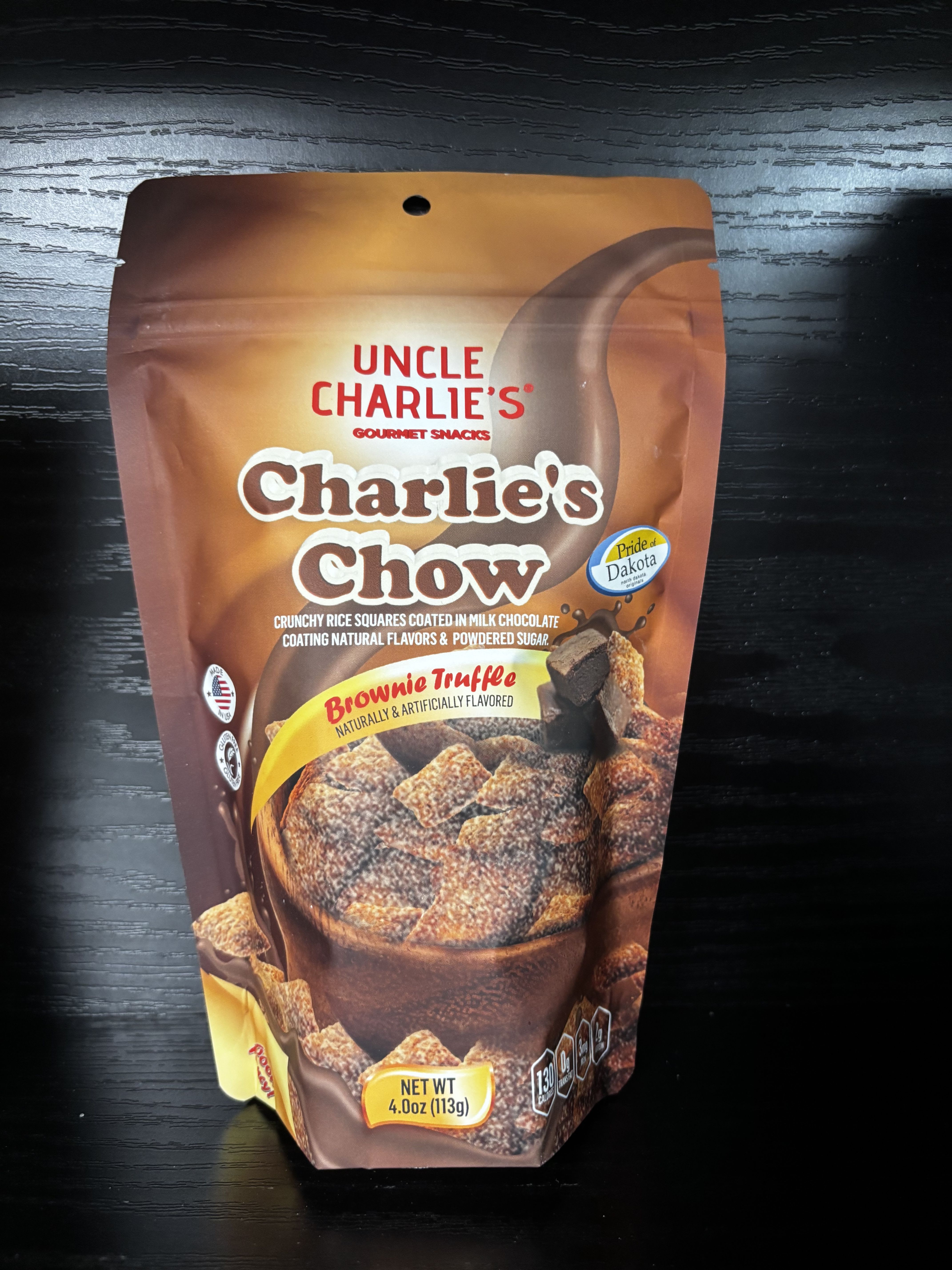 Charlie’s Chow – Brownie Truffle - Rich, chocolatey, and irresistibly crunchy, Charlie’s Chow Brownie Truffle is a decadent twist on a classic snack mix. Crispy rice squares are generously coated in smooth milk chocolate and brownie-inspired flavor, then dusted with powdered sugar for the perfect sweet finish. Every bite tastes like a chocolate brownie in snack form—indulgent, comforting, and totally crave-worthy. Perfect for gifting, dessert tables, movie nights, or satisfying any chocolate lover’s sweet tooth.