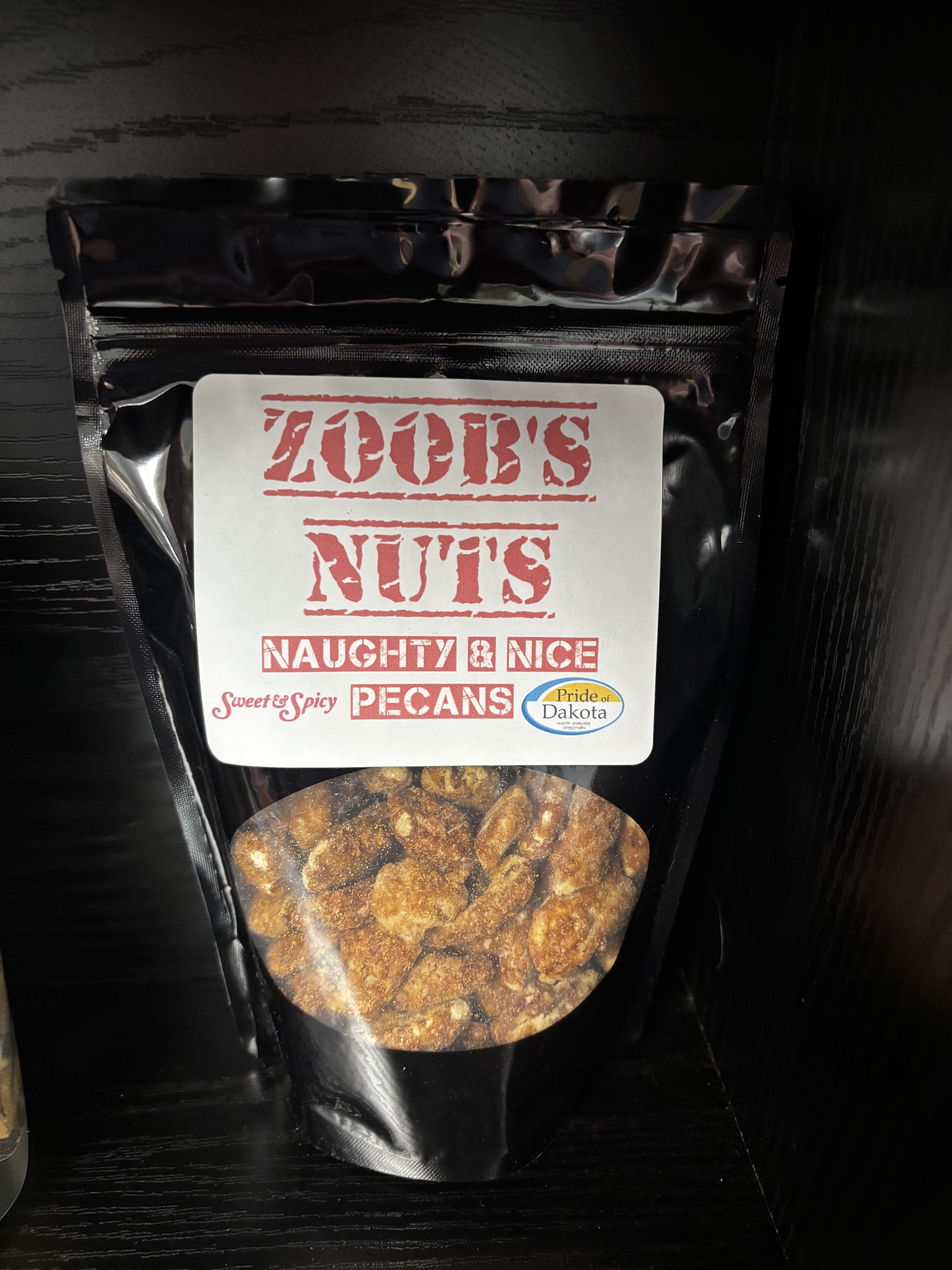 Zoob’s Nuts – Naughty &amp; Nice Sweet &amp; Spicy Pecans - A little sweet, a little spicy, and totally irresistible. Zoob’s Naughty &amp; Nice Pecans are perfectly roasted and coated in a crave-worthy blend of warm spices and sweetness for a bold flavor with just the right kick. These pecans strike the perfect balance between indulgent and snackable—great for everyday treating, holiday gifting, charcuterie boards, or topping salads and desserts. A customer-favorite Pride of Dakota snack with personality in every bite.