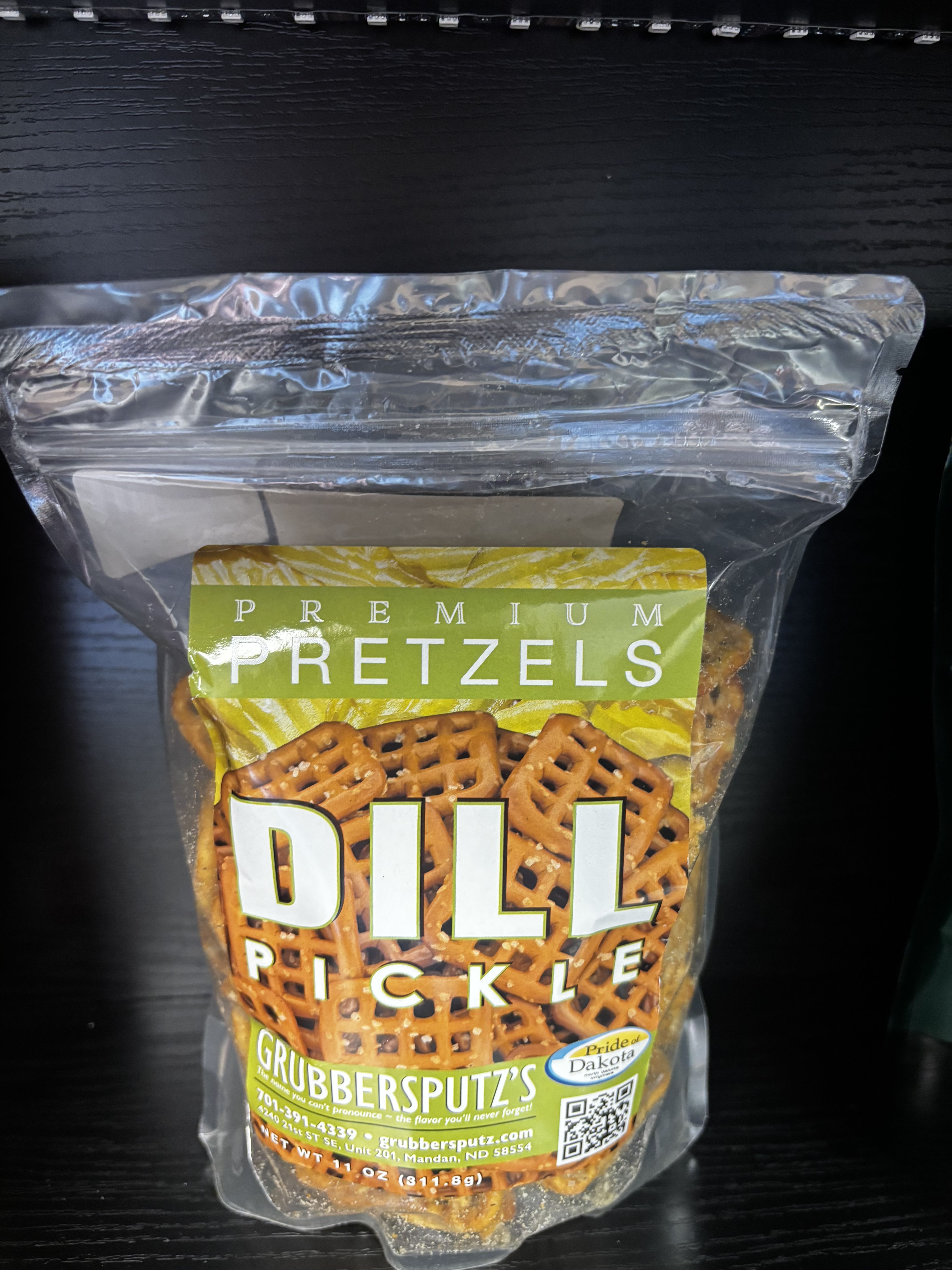 Grubbersputz’s Premium Dill Pickle Pretzels - Crunchy, bite-sized pretzels generously  coated with bold dill pickle seasoning for the perfect mix of tangy, salty, and savory flavor. Grubbersputz’s Premium Dill Pickle Pretzels deliver an addictive crunch with a zesty kick in every bite. Proudly made in North Dakota and featuring Pride of Dakota products, they’re a must-have snack for pickle lovers and a fun addition to gift baskets or everyday snacking.