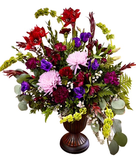 Eternal Honor Tribute - A rich and elegant tribute that speaks of deep love and lasting respect. This striking arrangement features a regal mix of burgundy carnations, bells of Ireland,  lavender mums, amaryllis, and soft greenery, artfully arranged in a classic pedestal vase. Accents of purple lisianthus and textured foliage add warmth and dimension. A dignified and graceful display, perfect for honoring a life well lived and offering comfort to loved ones.