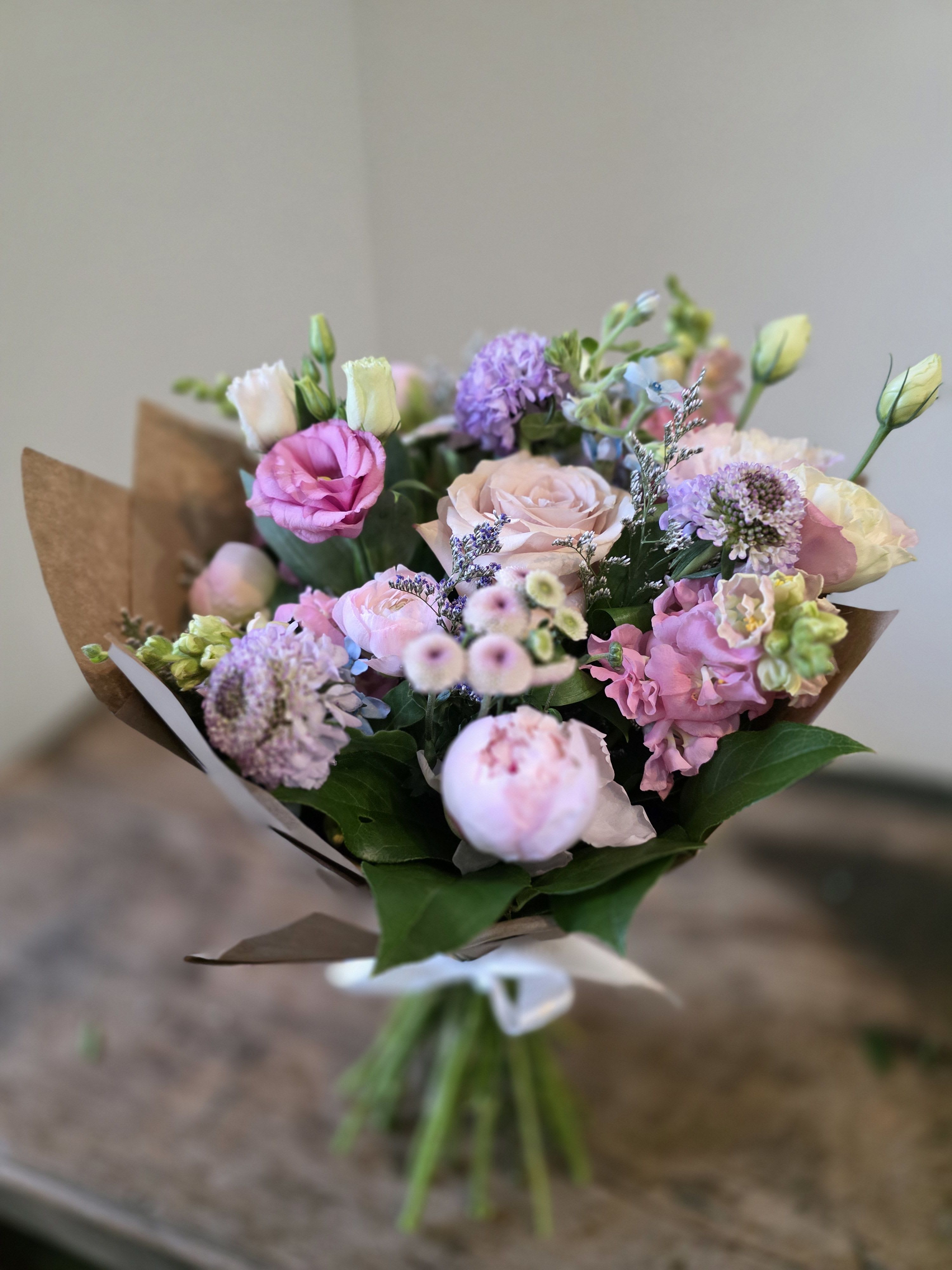 Designer’s Choice Wrapped Bouquet  - This will be the best and most interesting seasonal blooms in the studio!    Wrapped with kraft paper and tied with raffia.