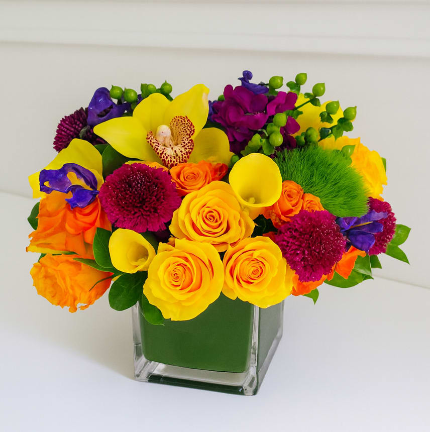 Color-Fall - This classic colorful arrangement is presented in a 6" cube vase. It features bright tropical colors.  