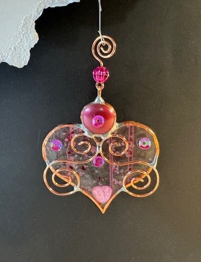 A Bit of My Heart Stained Glass Keepsake (clear &amp; pink striped) - These beautiful hearts say it all!!! They are made out of stained glass and come in several different colors and tones of pink and red.  They can be hung by a suction cup (not included) or by a piece of thread from lamps, mirrors, windows, etc.  Can be used as an add-on to any of our floral arrangements of shipped as a separate item.  These hearts are available as wholesale items by reaching out to us at 540-810-2161.