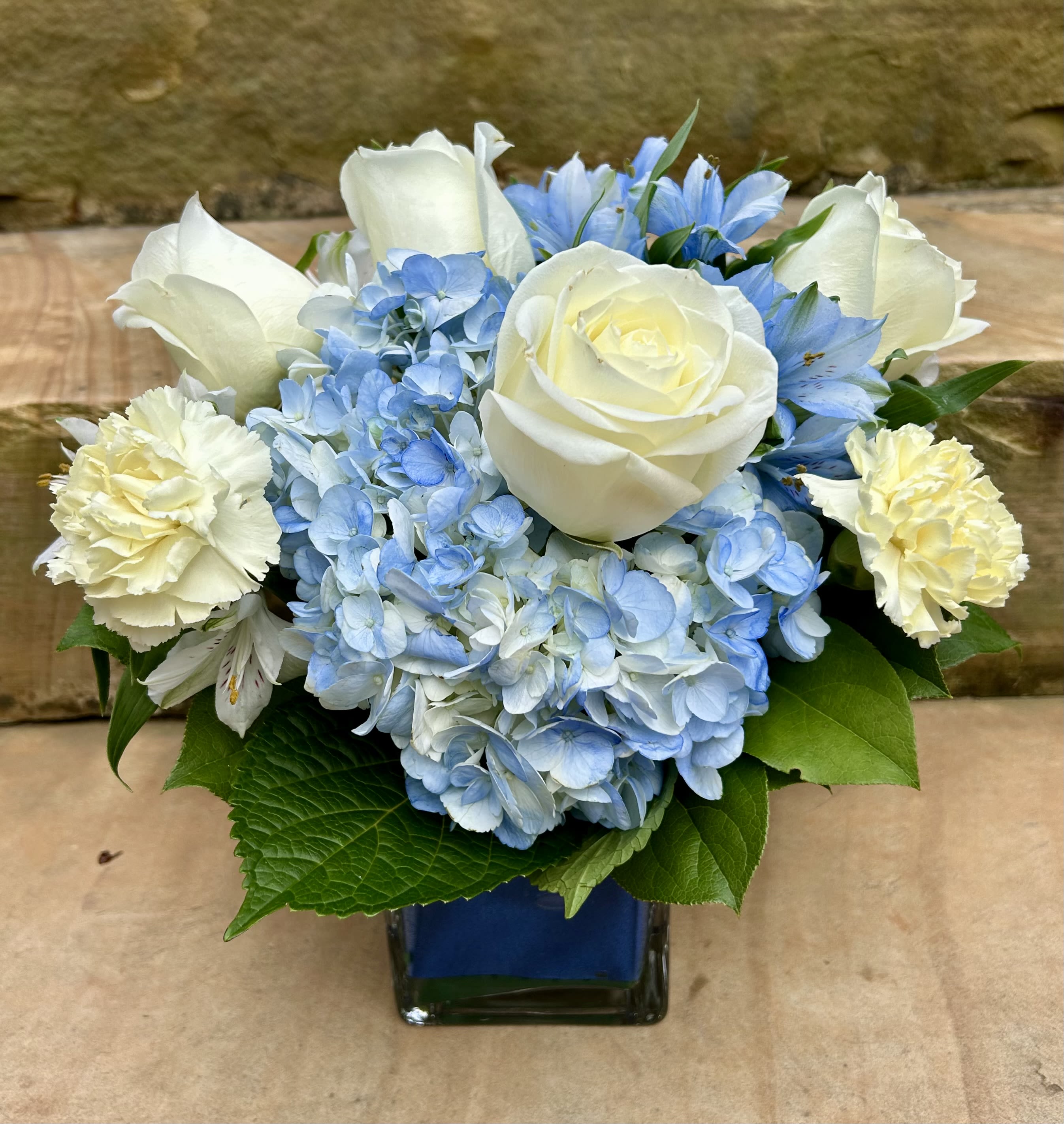 Captivating Cobalt - A beautiful blue and white arrangement of flowers designed in a low cobalt cubed vase.