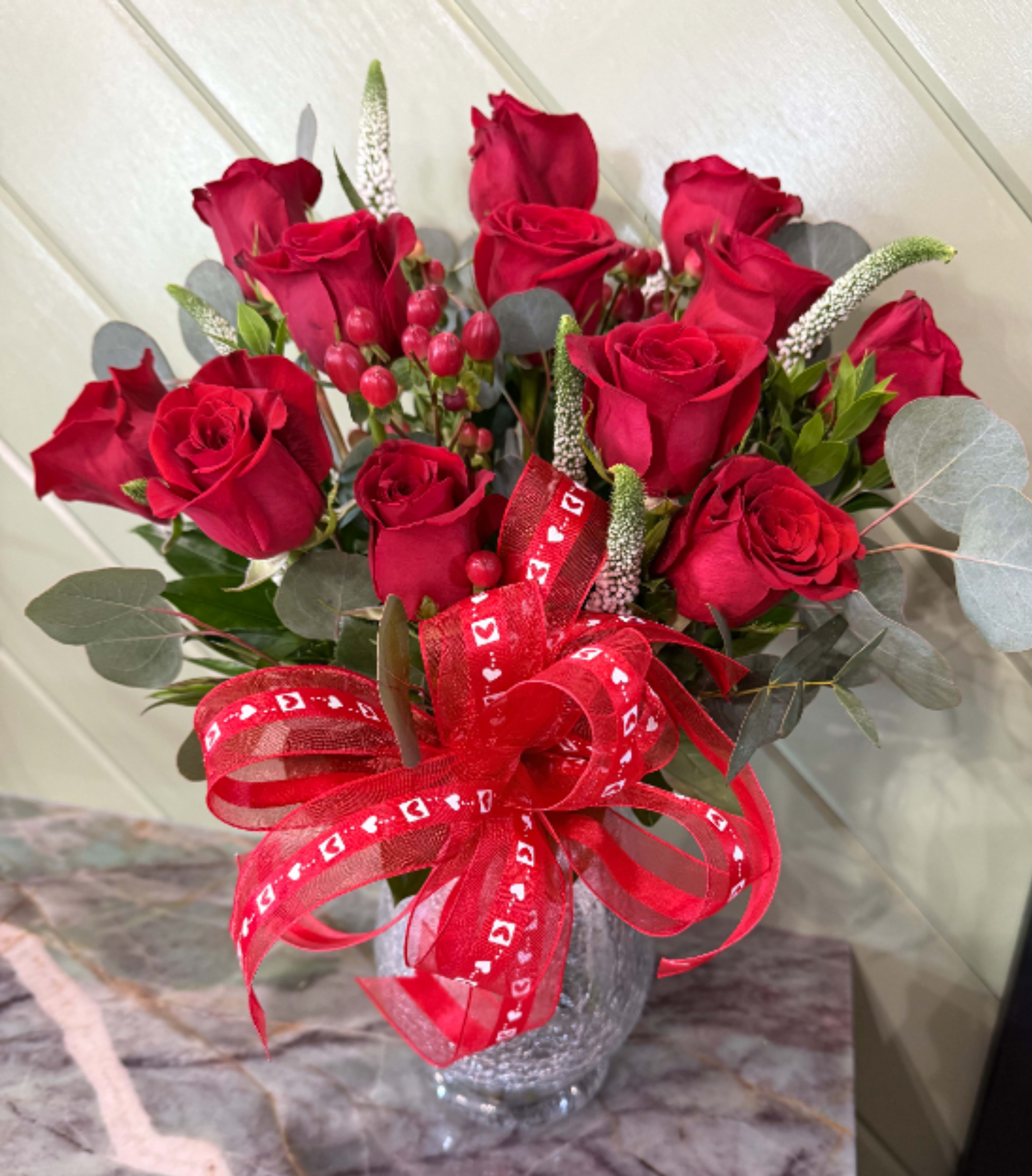 A Lovers Dream - This dozen rose bouquet is a perfect blend of red roses, in a medium height vase, mixed greens, berries and veronica
