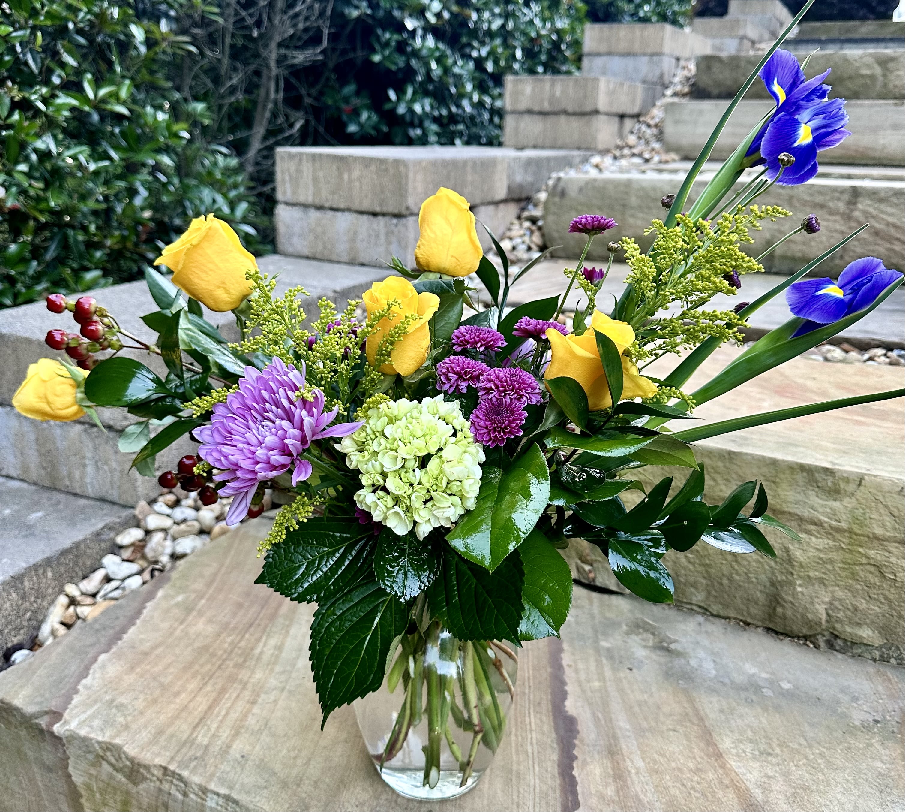 Iris of Love - A colorful arrangement of yellows, purples, pinks and red flowers arranged in a glass vase to brighten someone’s day!