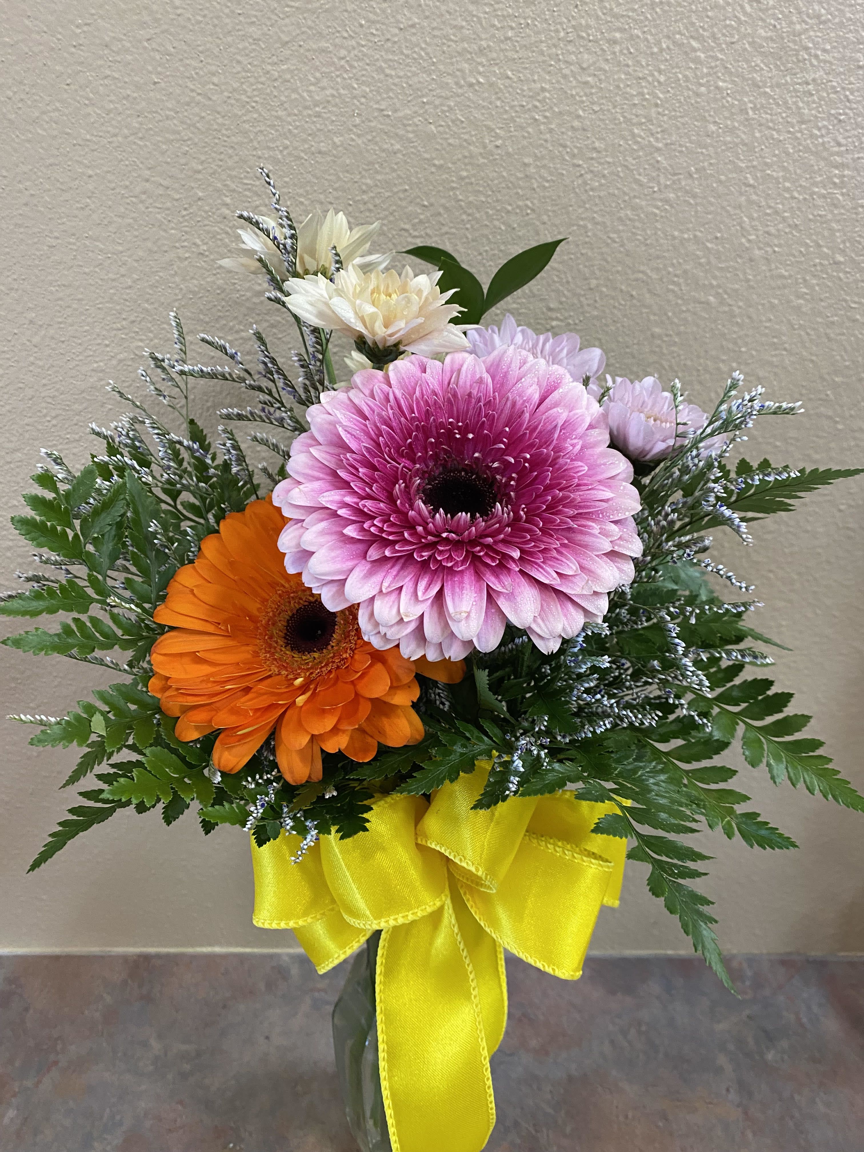 Cute as a Button - The name says it all with those gerberas and with daisies and filler, it is Cute as a Button. This is a bud vase arrangement. Colors may change depending on availability