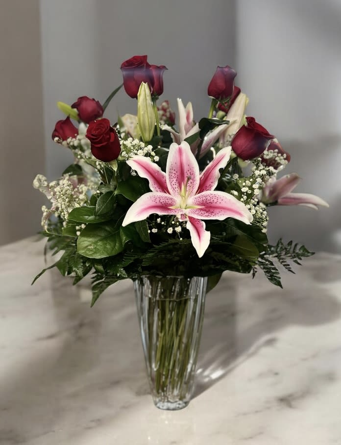 Swirl Vase Rose and Lily Elegance - Swirl vase arrangement with red roses and pink lilies.