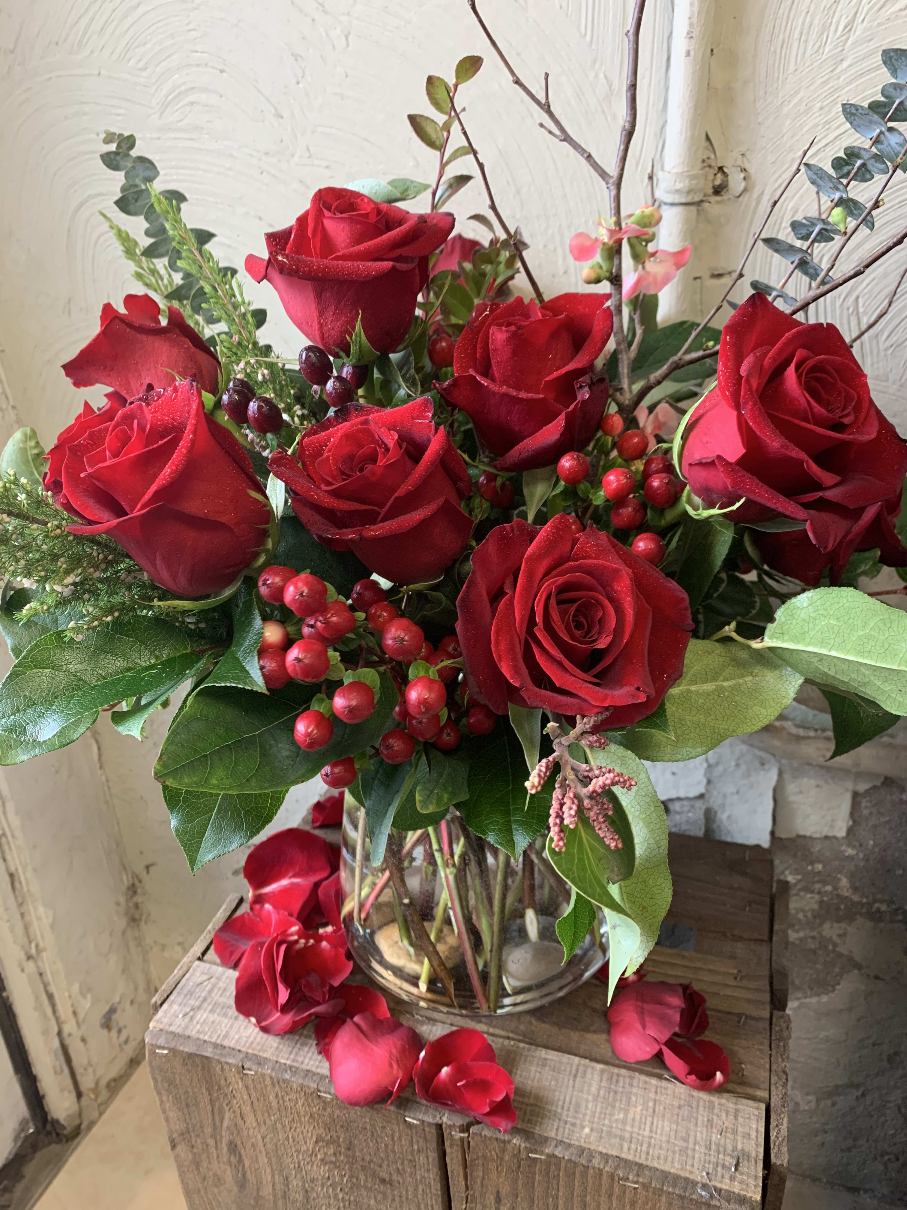 Dozen Long Stemmed Roses - These red roses with hypericum and eucalyptus are classic! A perfect traditional gift to express love.. Standard is 12 Roses, Deluxe is 18 Roses and Premium is 24 Roses.