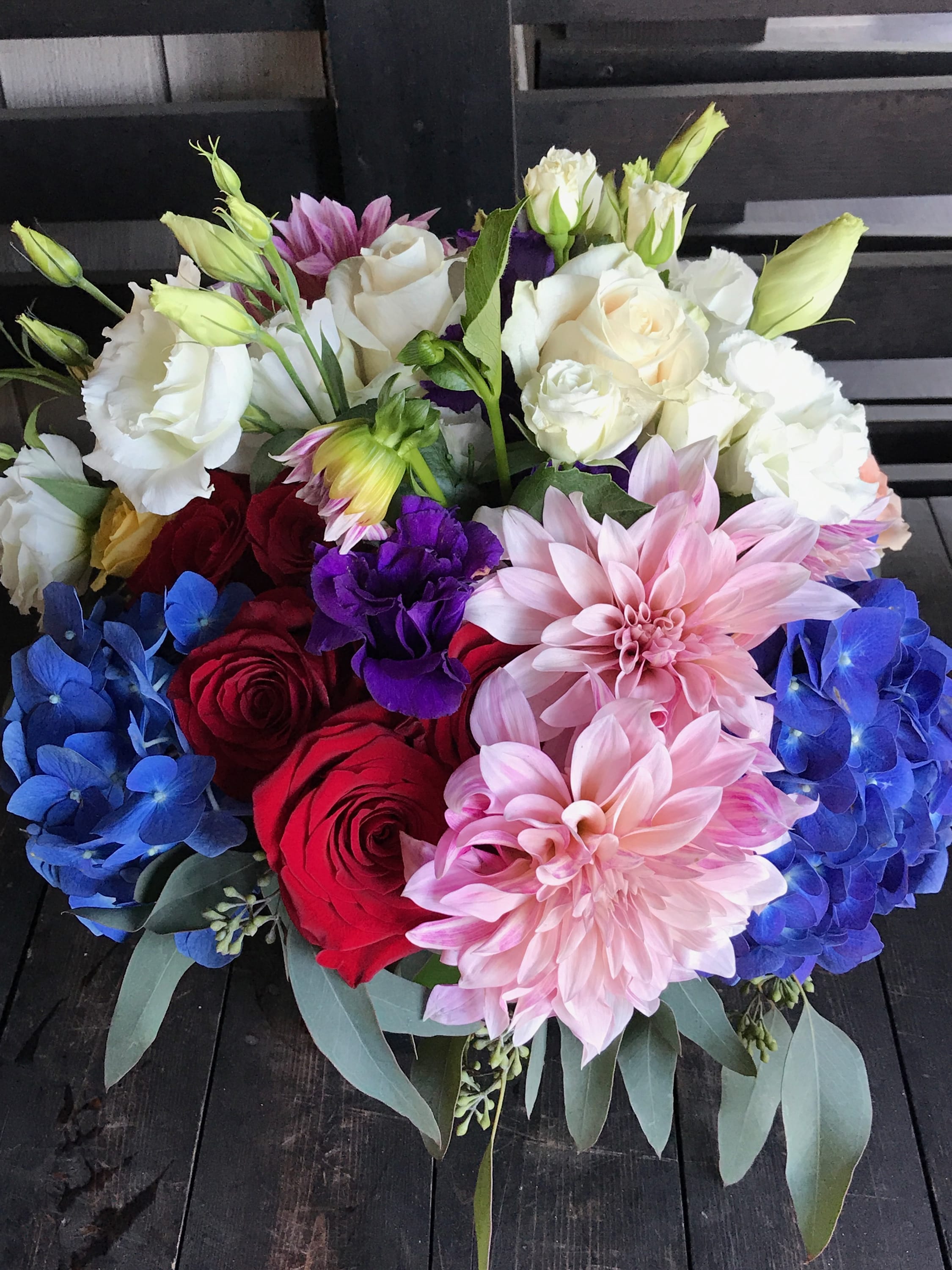 Garden Mix - A mixture of colorful roses, hydrangeas, dahlias, lisianthus, seed eucalyptus arranged in clear square glass vase wrapped with tea leaves.  