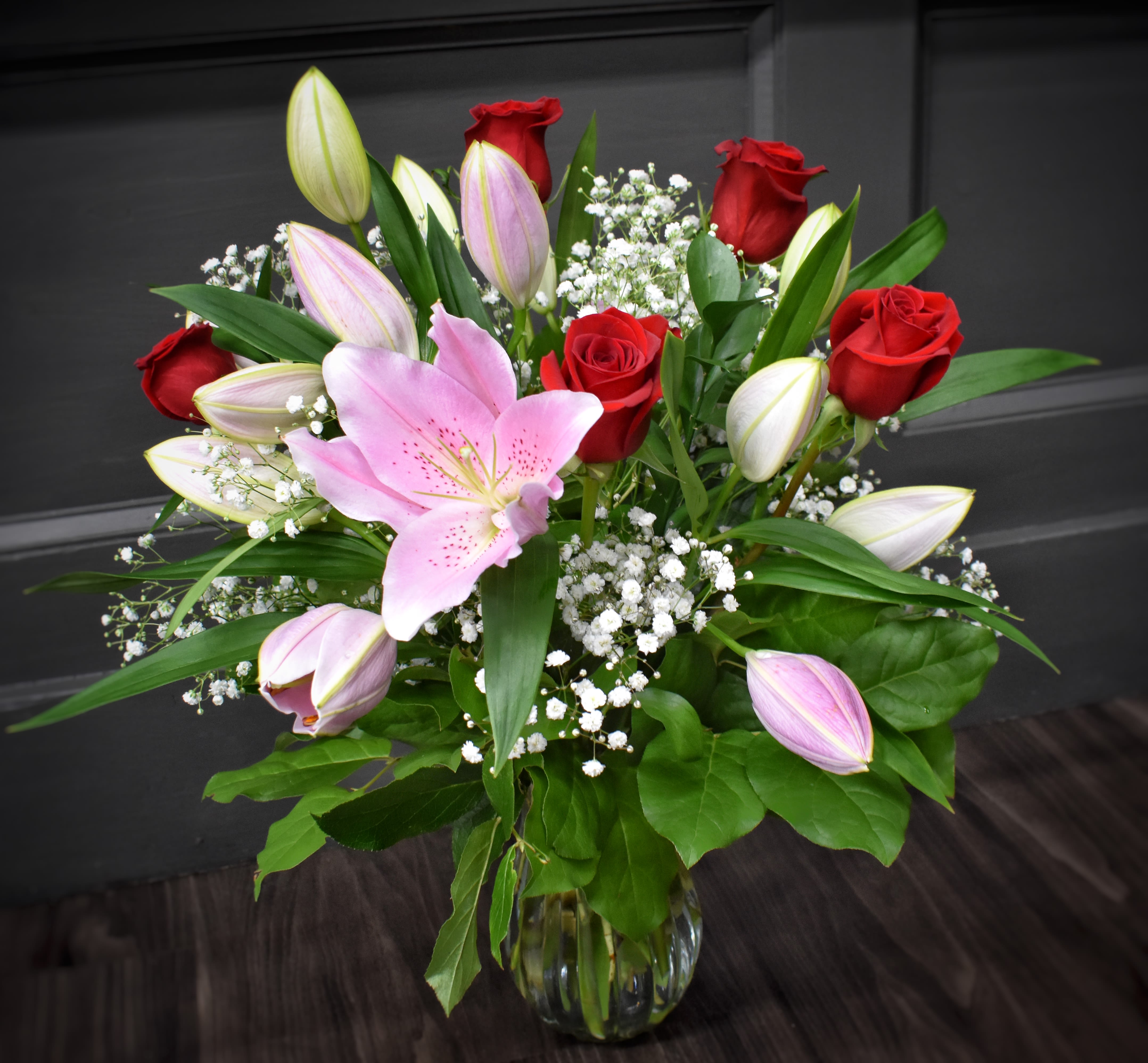 Roses and Lilies - Our most Popular Bouquet! - One of our most popular designs, this bouquet is designed in a glass vase with 6 long stemmed roses, 4 stems of fragrant oriental lilies, assorted green foliages and babies breath as an accent flower. 