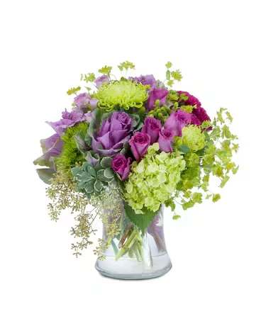 Magenta Mystery - A magical mixture of magenta and green flowers, including roses, hydrangea, hypericum berry and ornamental kale, designed in a large clear glass vase.