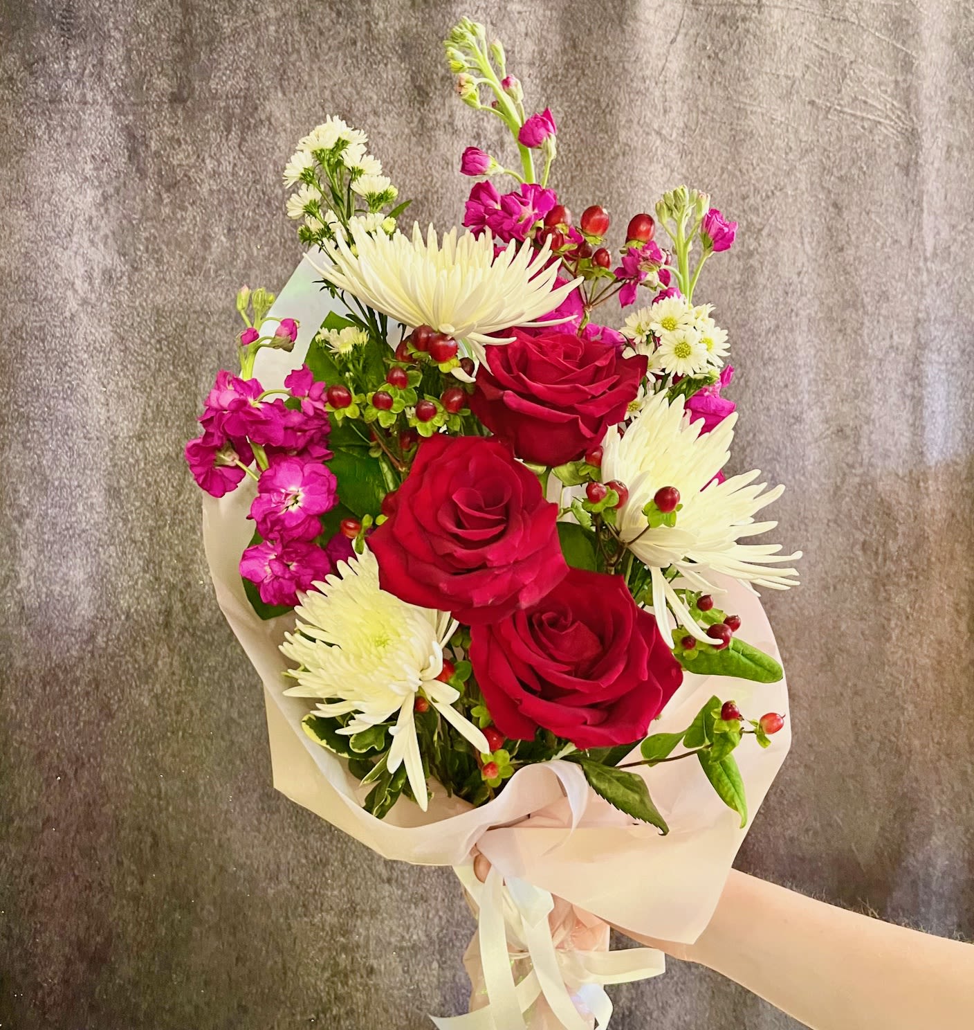 My Love, My Heart - Wrapped bouquet of loose stems in colors of pink, white and red. Includes 3 red roses, red berries, white Cremone mums, and stock.  