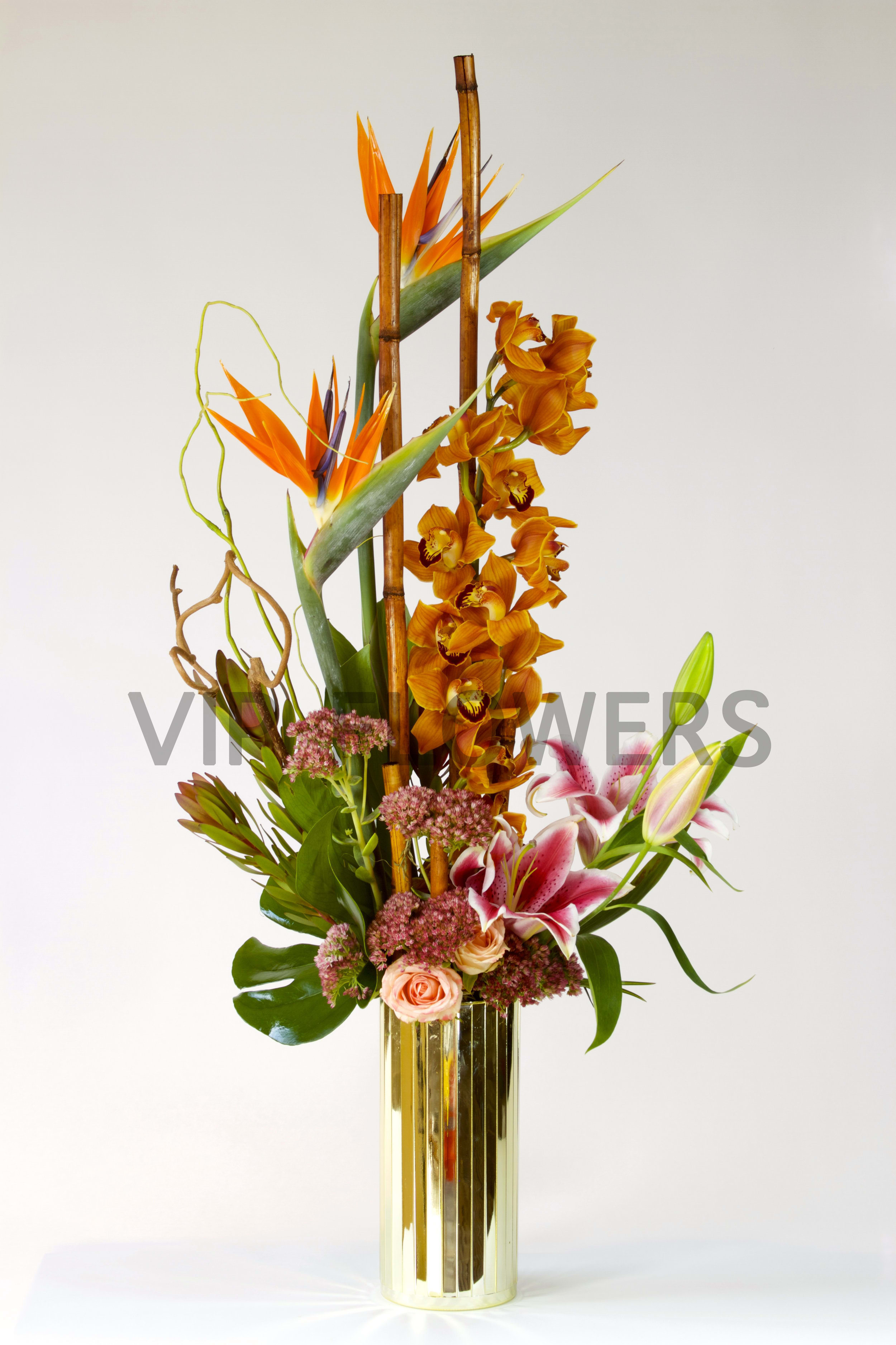 Golden Tropical Bliss - This majestic gold themed floral bouquet is one of its kind. One for a magnificent event! With the mix of gold and pink this bouquet is a natural classic! Flowers included are birds of paradise, roses, spray roses, Orchid, stargazer lilies, and more!     Substitutions may be necessary to ensure your arrangement or specialty gift is delivered in a timely manner. The utmost care and attention is given to your order to ensure that it is as similar as possible to the requested item (Please note that some flowers and colors may vary due to seasonality.)