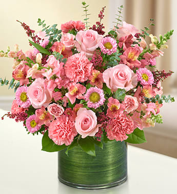 Cherished Memories - All Pink - Product ID: 95385   Send a gift of lasting tribute that captures their cherished memories of loved ones who have passed on. Our color-soaked, all-pink arrangement of roses, spray roses, snapdragons, alstroemeria, carnations and more is tastefully arranged in a glass cylinder vase to offer a comforting message. Fresh arrangement of pink roses, spray roses, snapdragons, alstroemeria, carnations, asters and heather, gathered with variegated pittosporum, salal and spiral eucalyptus Hand-designed by our expert florists in a stylish clear glass cylinder vase wrapped with a Ti leaf ribbon; vase measures 6"H Appropriate for the service or the home of friends and family members Large arrangement measures approximately 16"H x 17"L Medium arrangement measures approximately 15"H x 16"L Small arrangement measures approximately 14"H X 15"L Our florists hand-design each arrangement, so colors, varieties, and vase may vary due to local availability