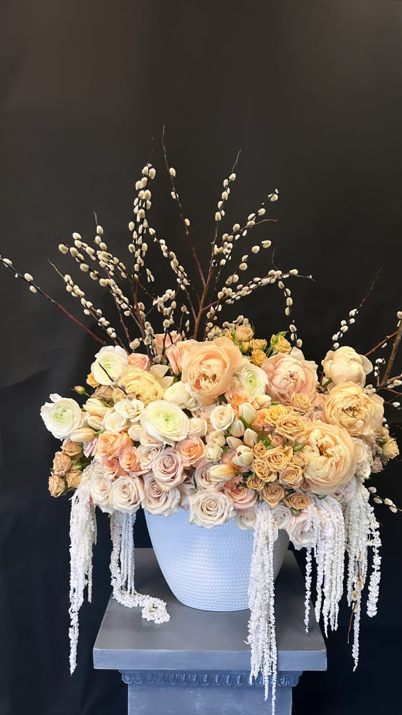 Glamour - Our "Glamour" arrangement is a gorgeous piece that consists Roses, Spray Roses, Tulips, Ranunculus, Peonies, Preserved Amaranthus with touches of seasonal brunches. 