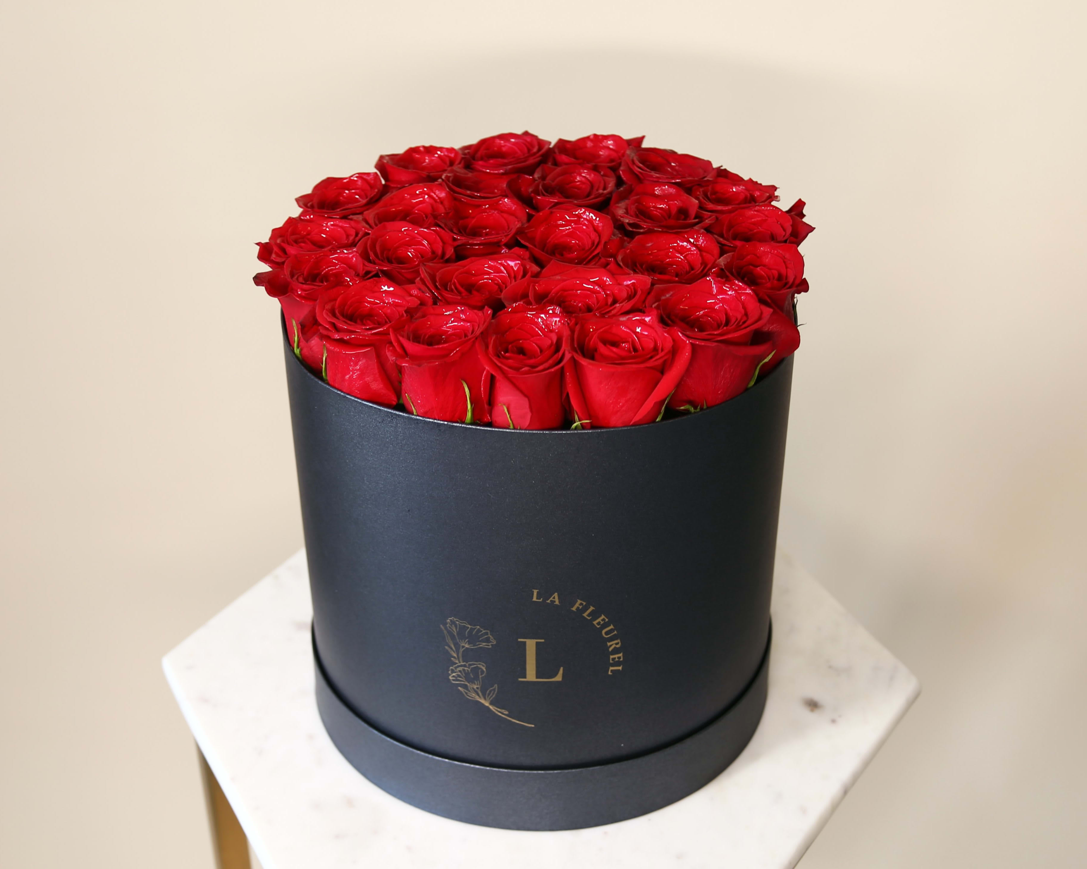 Red Freedom Box - This beautiful box contains a combination of 22 to 25 fresh roses in a black color box. This floral arrangement is the perfect gift for your loved one!     Arrangement includes: Fresh red roses Medium box measured at 9.75" Dia. x 9.25" H Custom greeting card