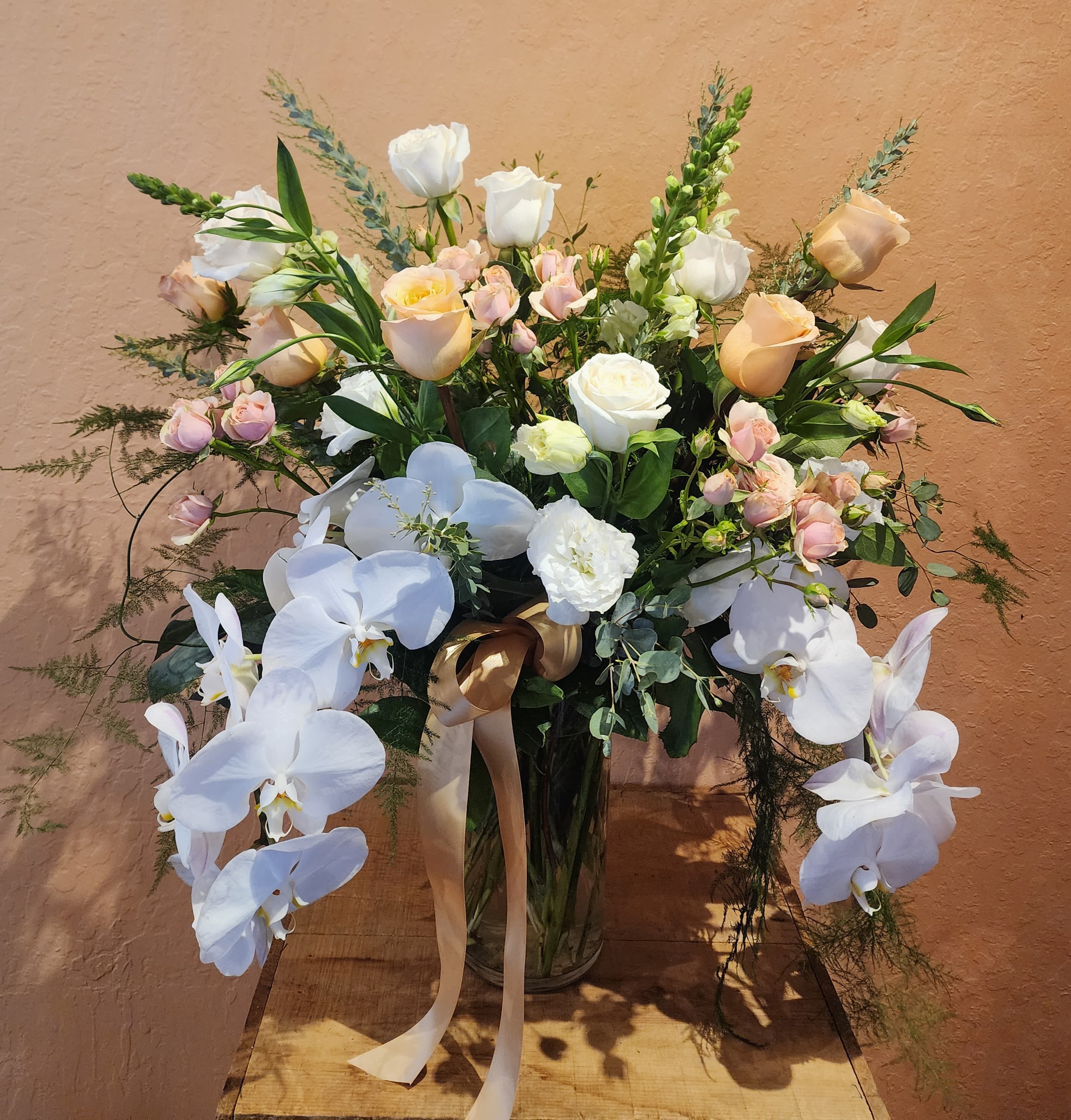 Abundant Peach - A grand display of peach and white roses.  Stunning white Phalaenopsis orchids Contemporary shape.  Our most showy peach and cream design. 