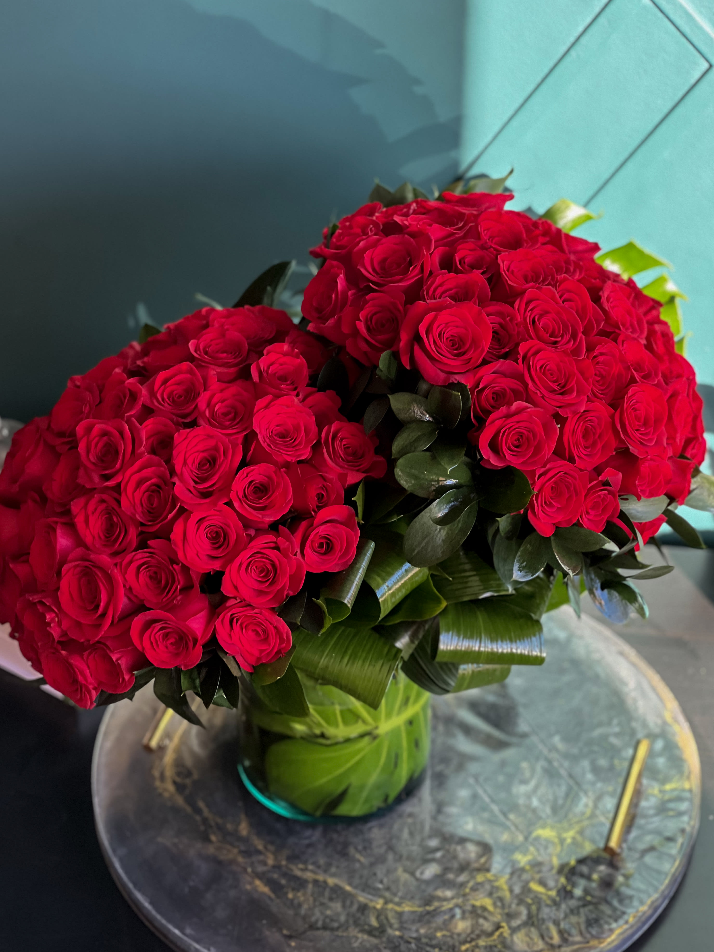 100 Roses arrangement in a clear vase  - 100 premium red roses in a clear vase with greenery accent 