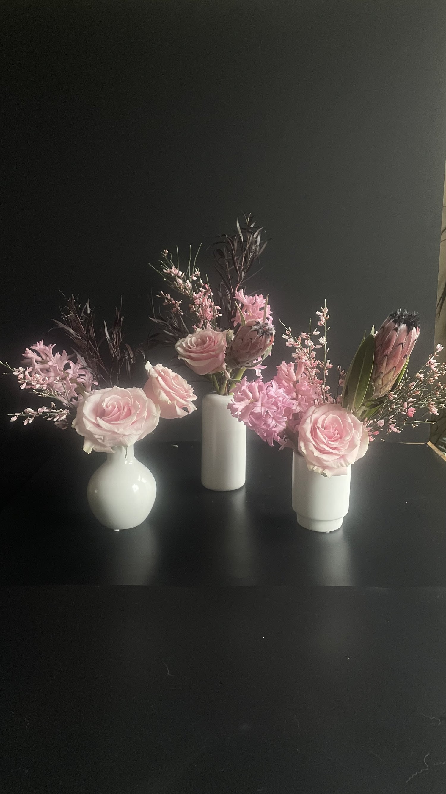 SOFT. Designer's Choice Bud Vase Arrangements - Discover the charm of our Bud Vase Arrangements, perfect for adding a touch of elegance to any space. These petite floral displays feature carefully selected blooms arranged artfully in sleek bud vases, showcasing the beauty of each flower.  Ideal for tabletops, shelves, or as a thoughtful gift, these arrangements bring a fresh and inviting atmosphere without overwhelming the senses. Each piece is designed to highlight the simplicity and grace of nature, making it a lovely addition to any decor style.  Whether you’re celebrating a special occasion or simply brightening your day, our Bud Vase Arrangements offer a delightful way to enjoy the beauty of flowers in a compact form.  Includes 3 Bud Vases