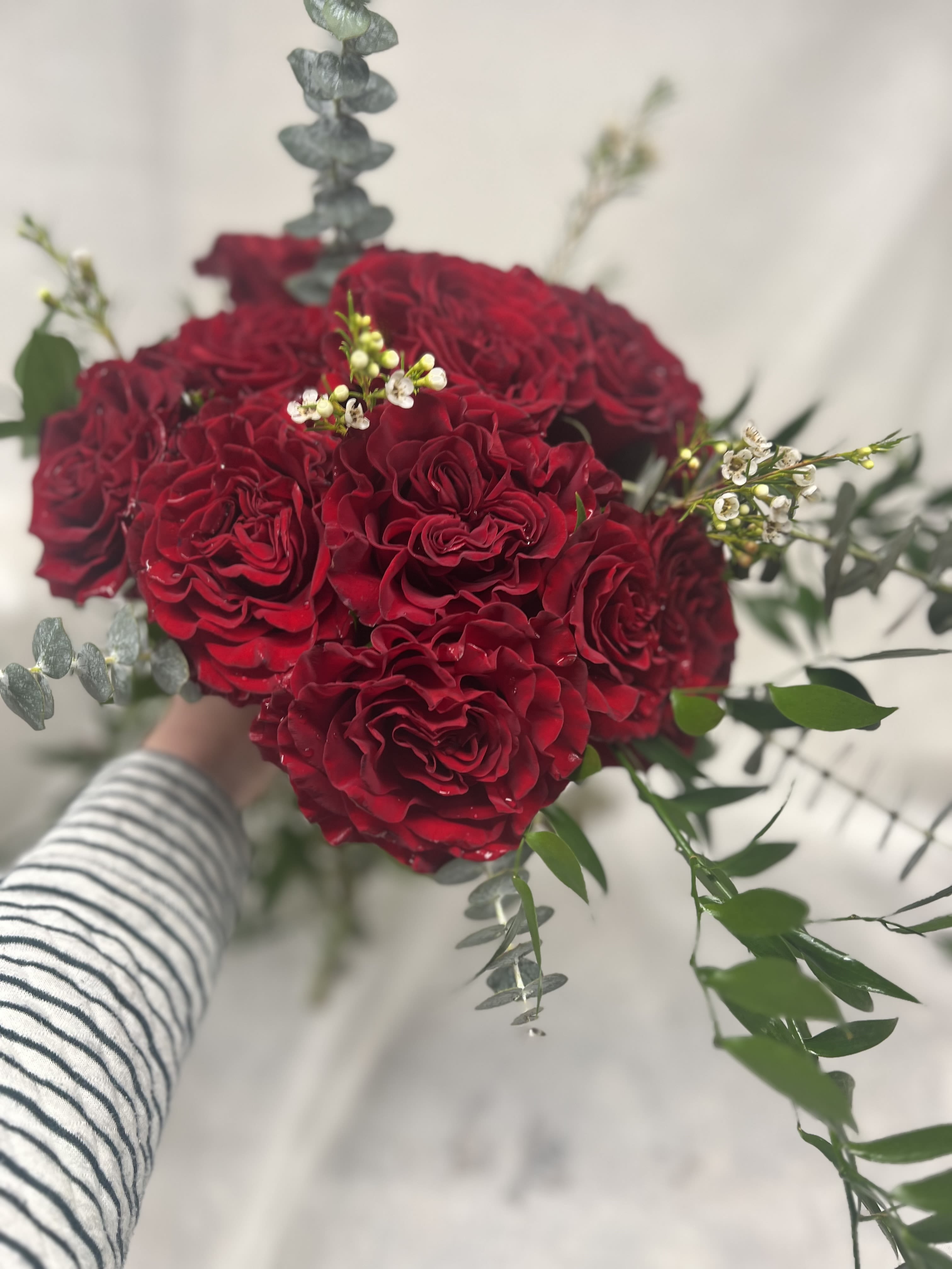 Love is a Rose- Red Rose Cut Bouquet - A gorgeous bouquet of Deep Red Heart Roses ( while supplies last ) Assorted greens and embellishments. An upgraded garden-type rose with the most beautiful heart petaling to remind her that she deserves the best of the best!