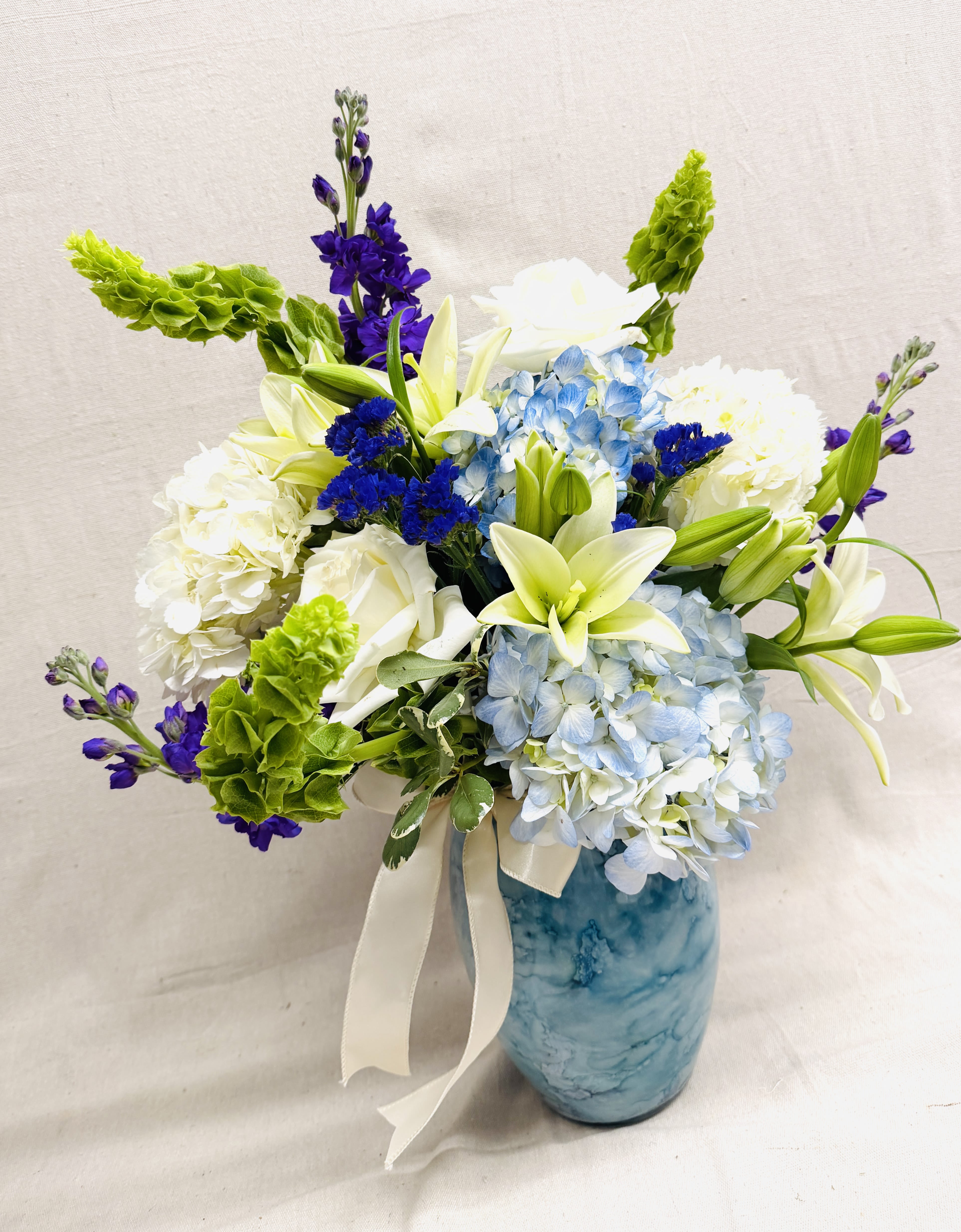 Something Blue - This beauty is full of blues and whites with a touch of purple.  Our designers will create an elegant display of blue hydrangeas mixed with some of the most beautiful blooms in our cooler in an extra special vase!  