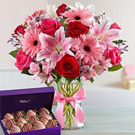 Pink Passion Bouquet with Strawberries Dipped In Chocolate - Wow Mom with this lavish bouquet of artistically gathered radiant red and hot pink roses, lovely pink lilies, sweet pink Gerbera daisies, and more inspired by the enchanting fields of the European countryside and strawberries dipped and decorated to perfection.