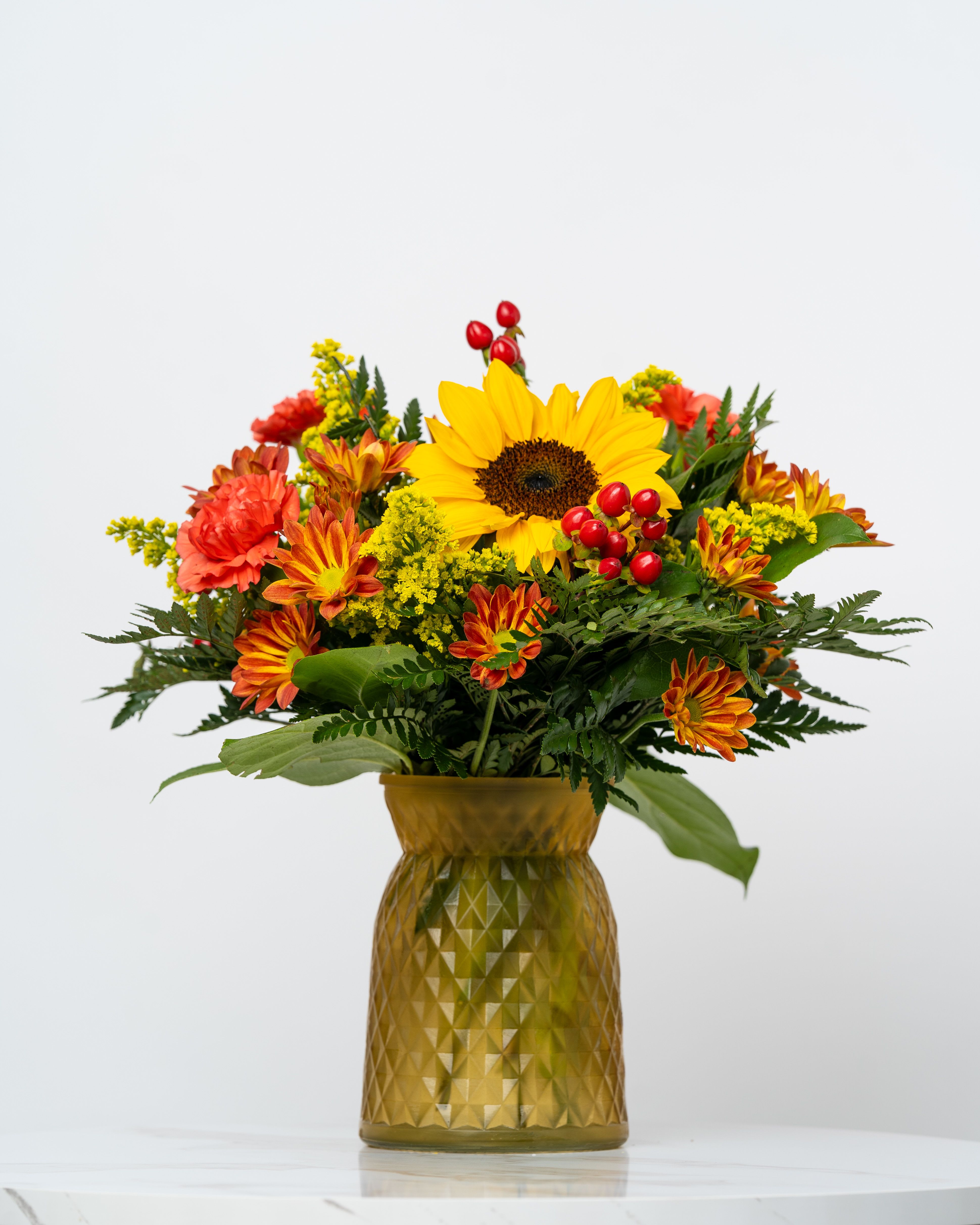 Our Holiday Collection: The Olivia - Designed with autumnal hues in a luxury frosted glass vase, our Holiday Collection blends colors and blooms of the season into arrangements that express friendship, charm, and heartfelt sentiment.  At Schultz Floral, each arrangement is one of a kind and styled just for your order in our Valparaiso Shop. Because we always use the freshest blooms, your final arrangement may not look exactly as pictured due to seasonal availability; additionally, this vase may come in yellow, green, or red depending on our stock the day of your flower delivery or pick up.