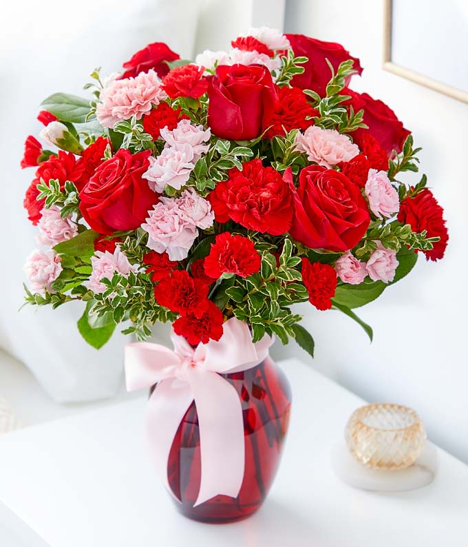 Save the Last Dance - This gorgeous bouquet includes red roses, red carnations, light pink carnations, red miniature carnations, light pink miniature carnations and green rhamnus accented with assorted greenery and a pink satin ribbon. Delivered in a ruby rose vase.