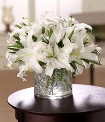Wonderous White - A dazzling display of warm white flowers and greens, our Wonderous White arrangement adds a touch of magic for any occasion. Filled with gorgeous white lilies, and fresh mixed greens. Pictured is Premium