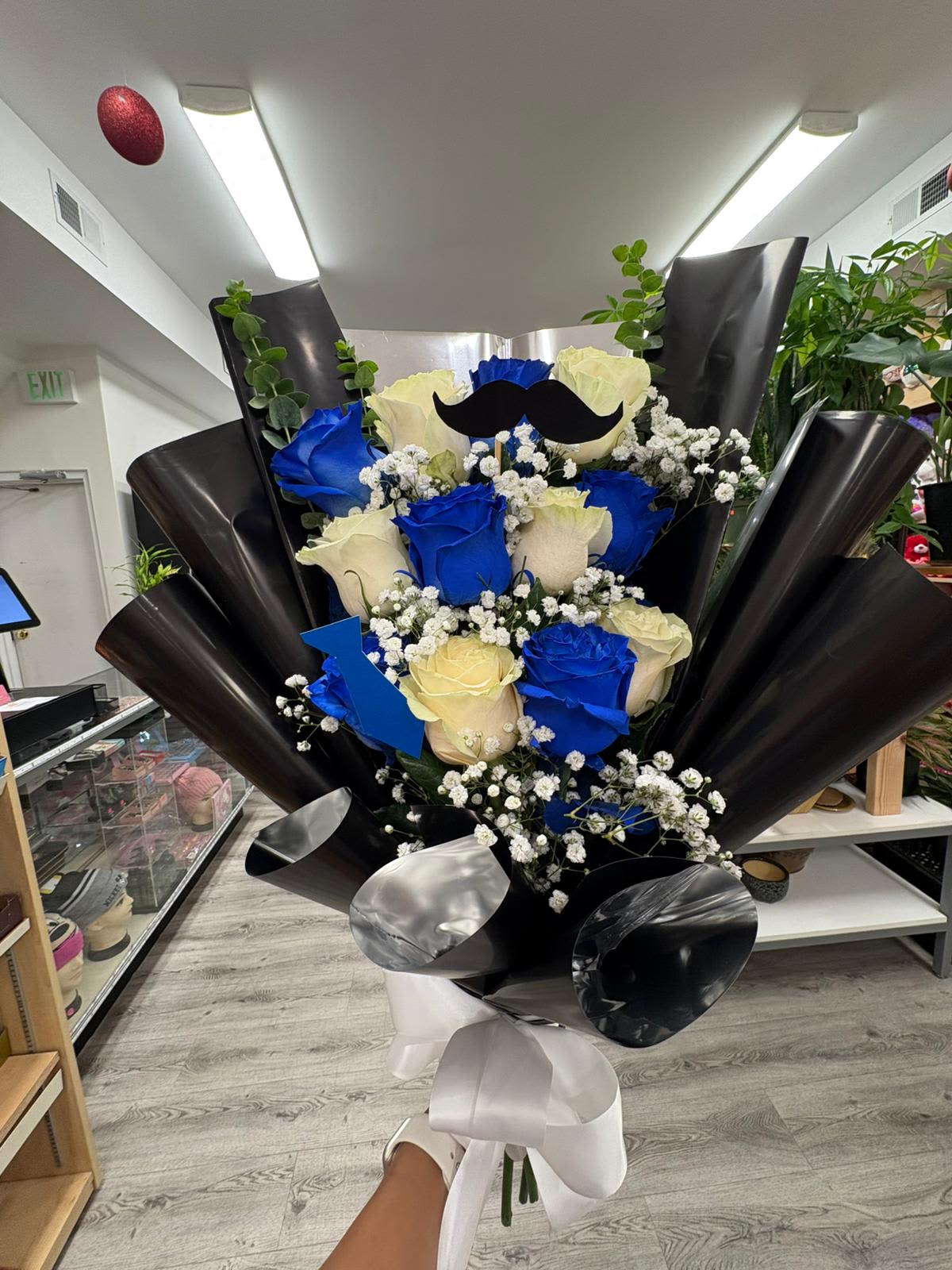 Gentleman Bouquet  - "Gentleman" combines white roses and intense blues, accented with gypsophila details, fresh eucalyptus and a satin black wrapper, crowned with an impeccable white bow.  Perfect to celebrate that dad who has always been an example of strength, love and style