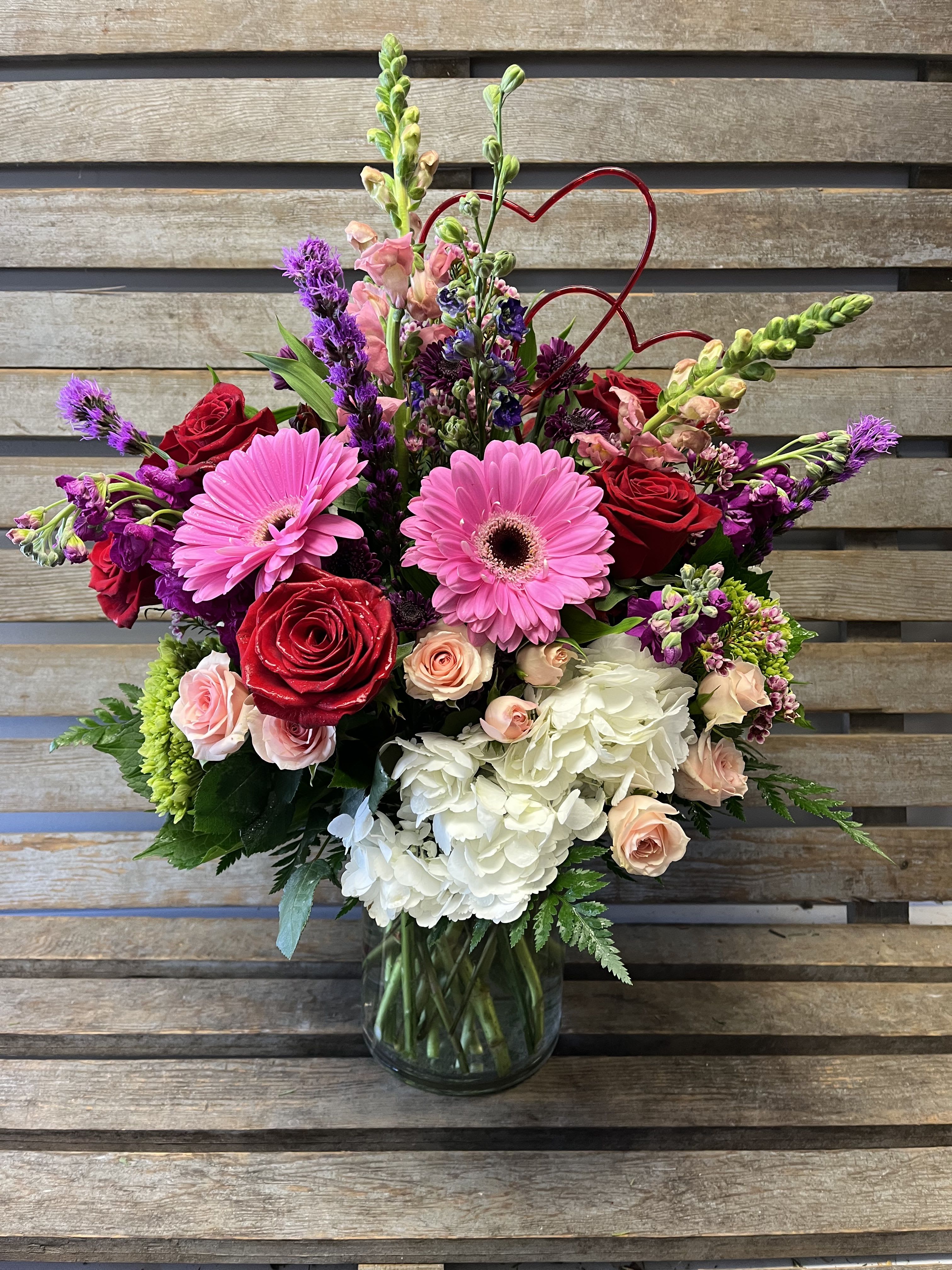 Valentine’s Day designer’s choice large cylinder.  - Large cylinder filled with designers choice of valentines Day flowers. Perfect choice if you would like to wow your sweetheart. Our designers will pick the freshest flowers in a Valentine’s Day color palette. 