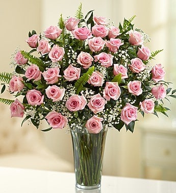Pink Roses - 12, 24 or 35  Medium Pink Roses arranged in a glass vase with greens and baby's breath.