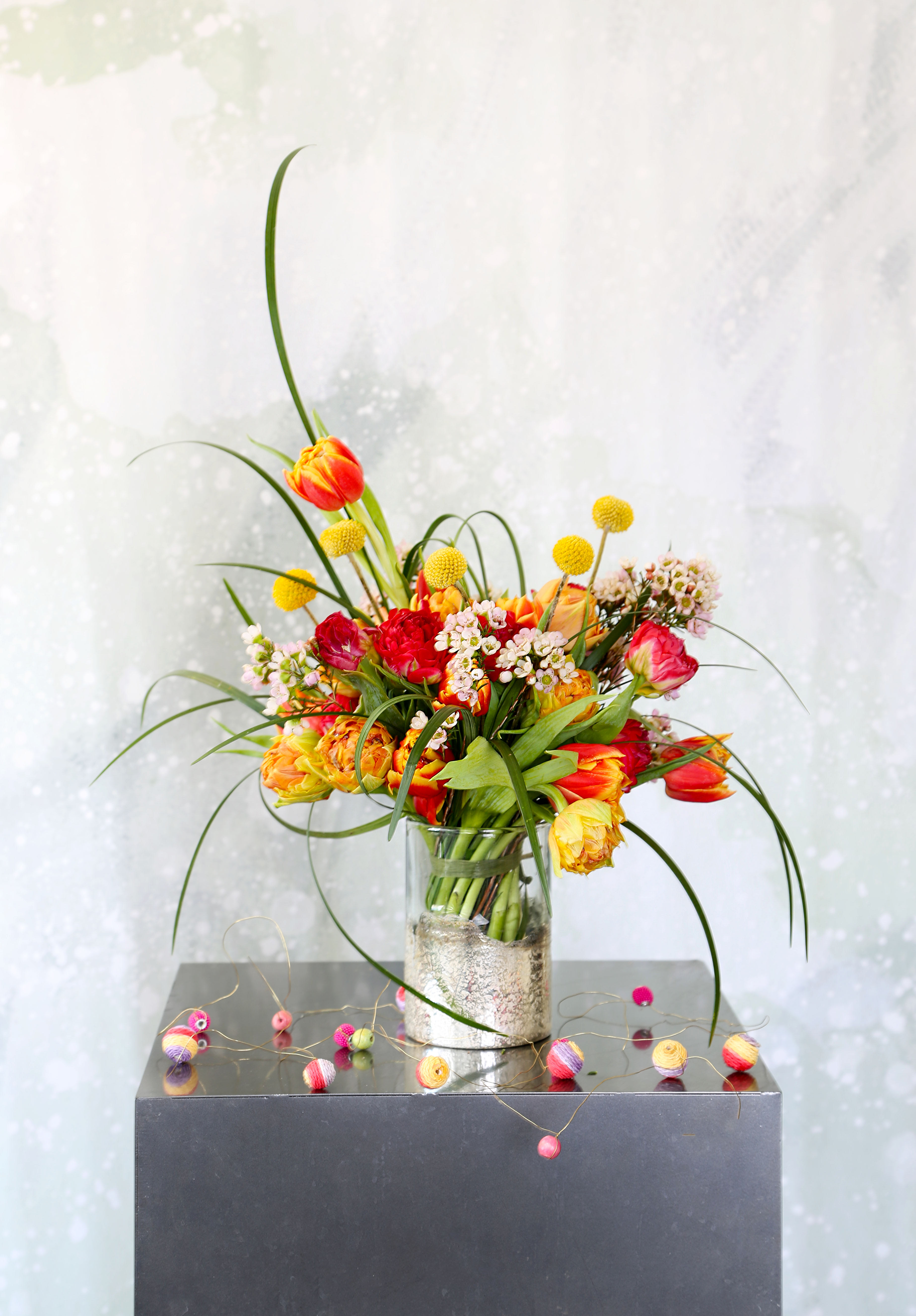 Little Tulip Posey - 27-30 stems Multi cheerful color Tulips arrange with Craspedia Billy, Bear grass with season bloom into an 7" height elegant handcraft silver and clear glass vase. We use our artistic touch to create a very cheerful, cute and unique posey good for office desk, coffee table, bedroom nightstand and bathroom decor.