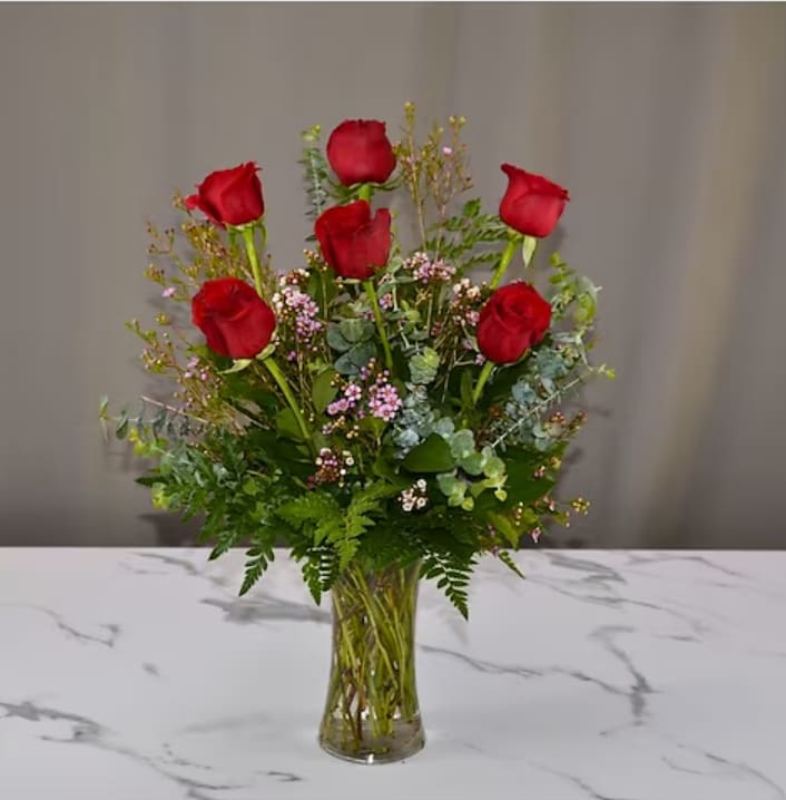 Romantic Radiance Bouquet - Celebrate love this Valentine’s Day with our Romantic Radiance Bouquet, a timeless arrangement that speaks from the heart. Six exquisite red roses stand proudly amidst a lush selection of fresh delicate ferns and accented with filler flowers for a soft, romantic touch.