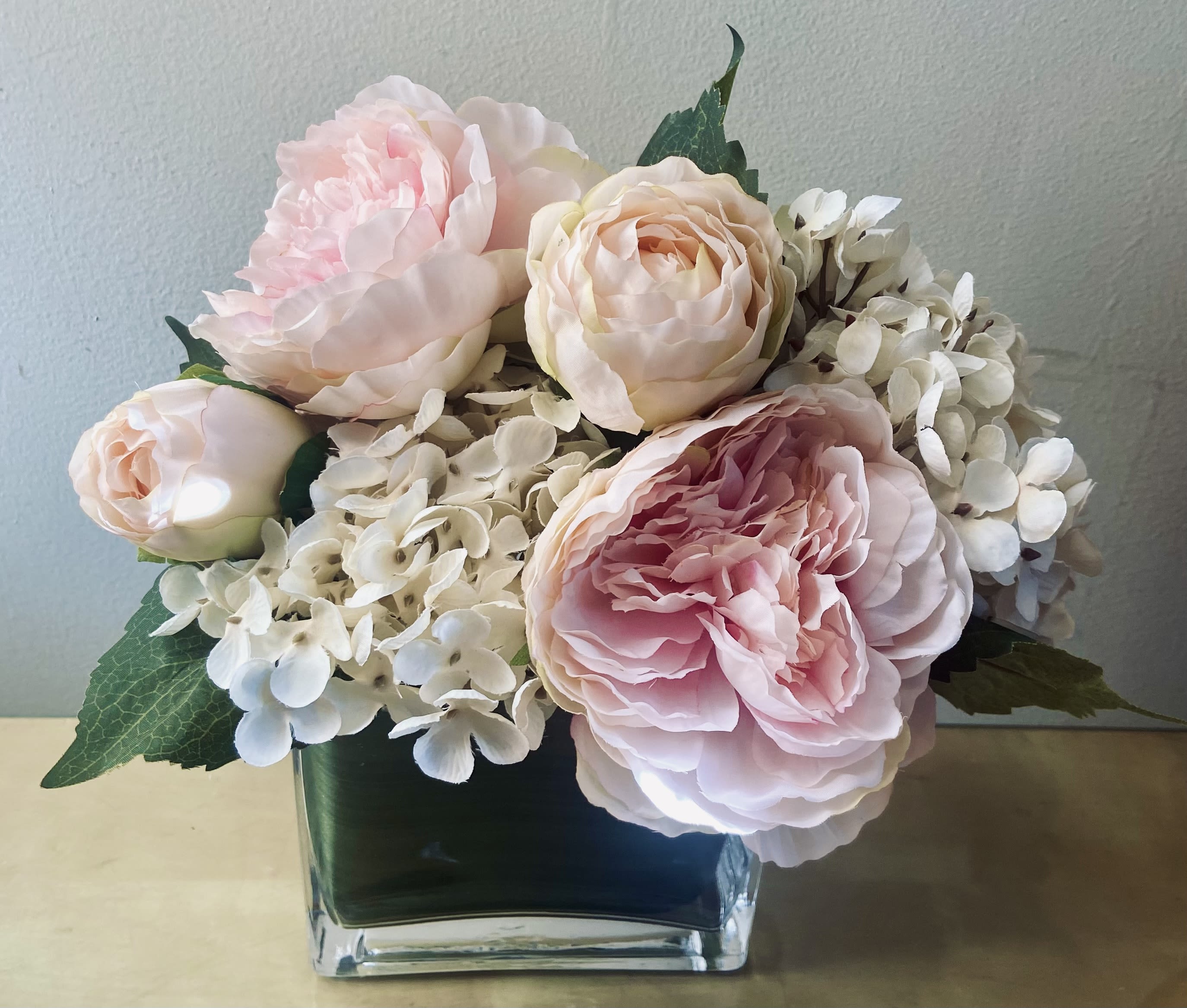 Blushing Beauty - Stunning high quality Silk arrangement of beautiful pink blush peonies and creamy hydrangea in a clear glass container with a foliage wrap.