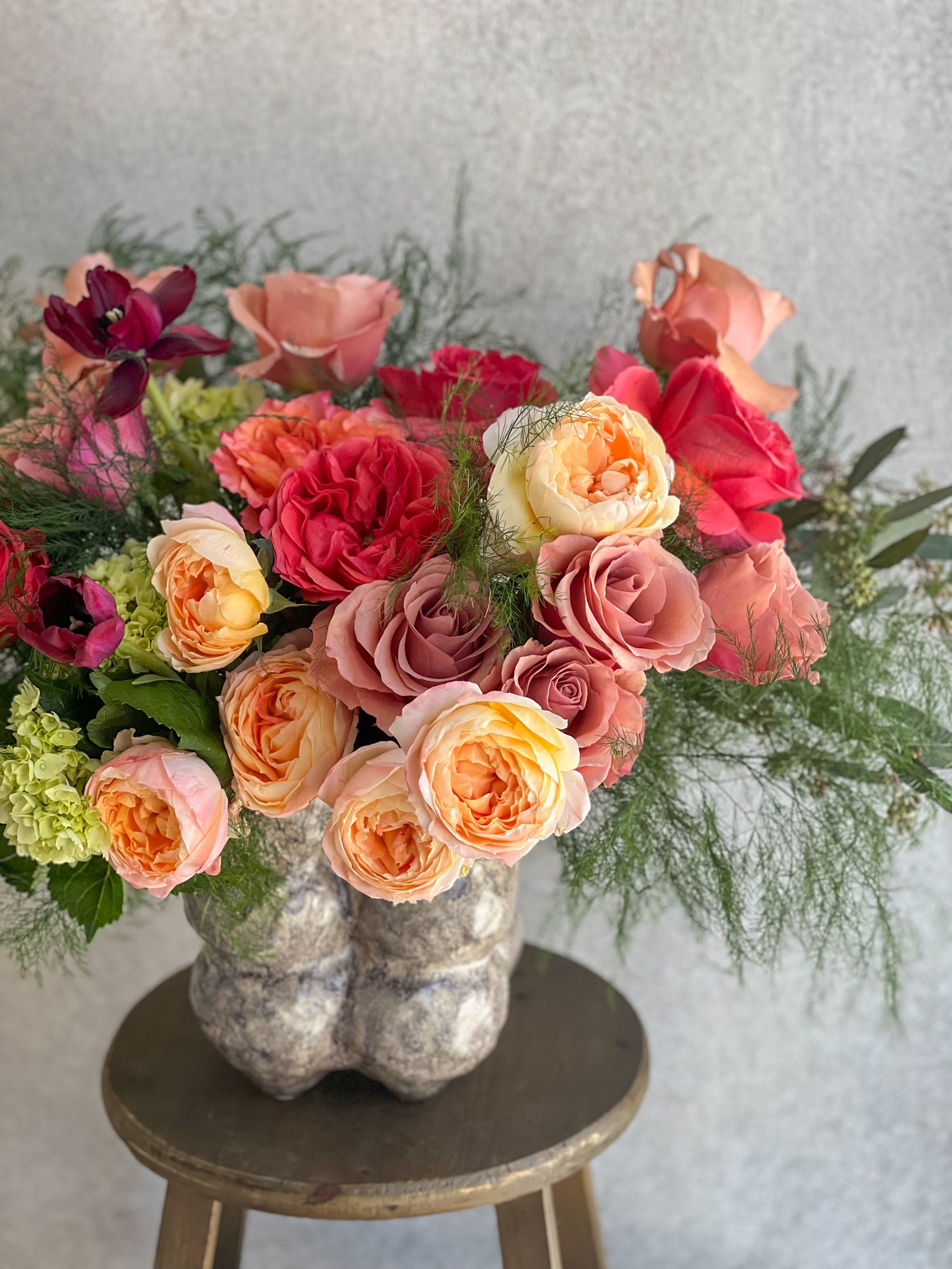 Amore  - A Large, Lush floral arrangement in a brown ceramic bubble vase. 