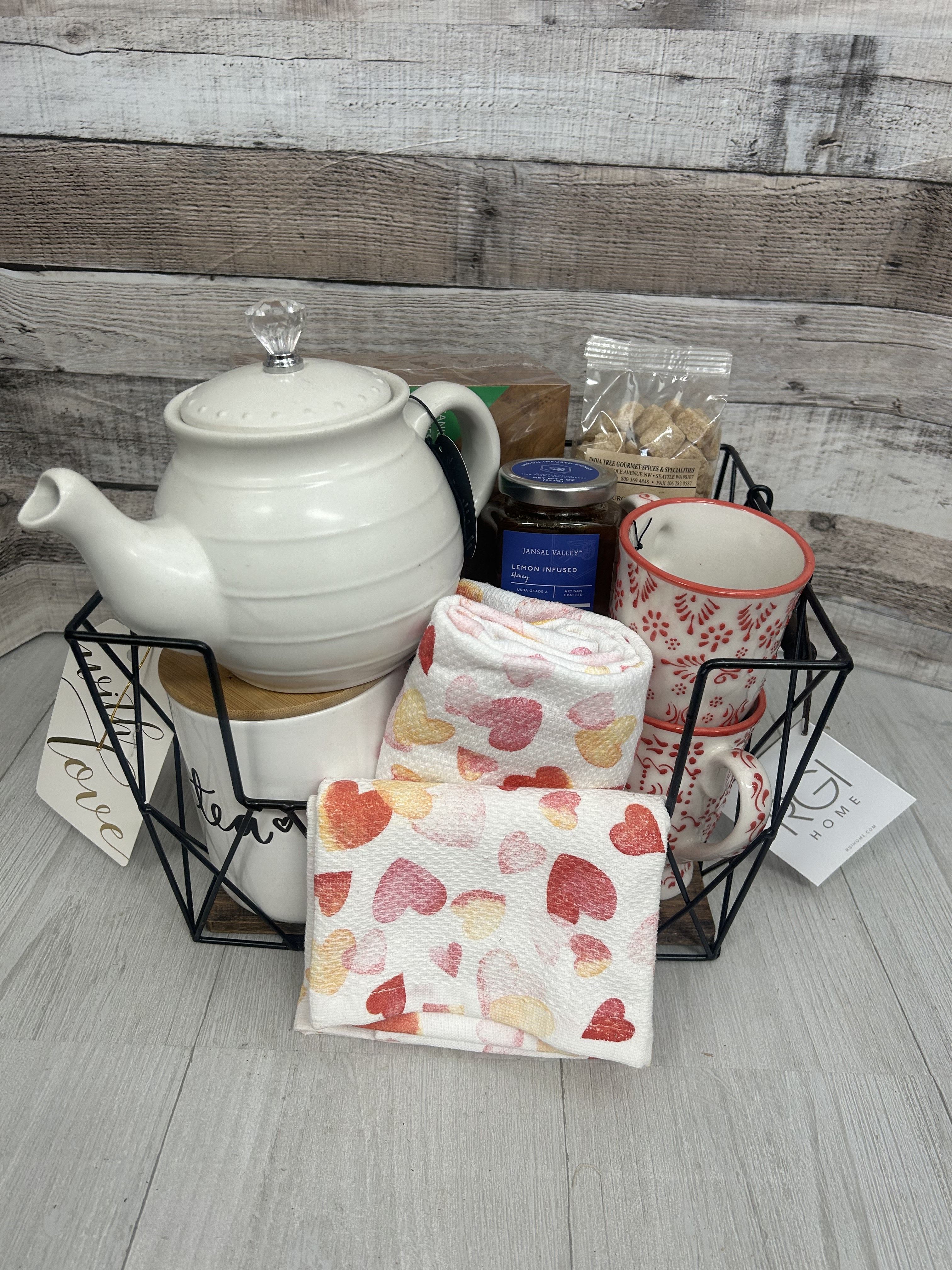Tea For Two Basket - What do you get your favorite person for Valentine's. This basket features, a teapot,  honey, a tea box, a tea canister, heart tea towels, 2 tea cups,  and demerara sugar
