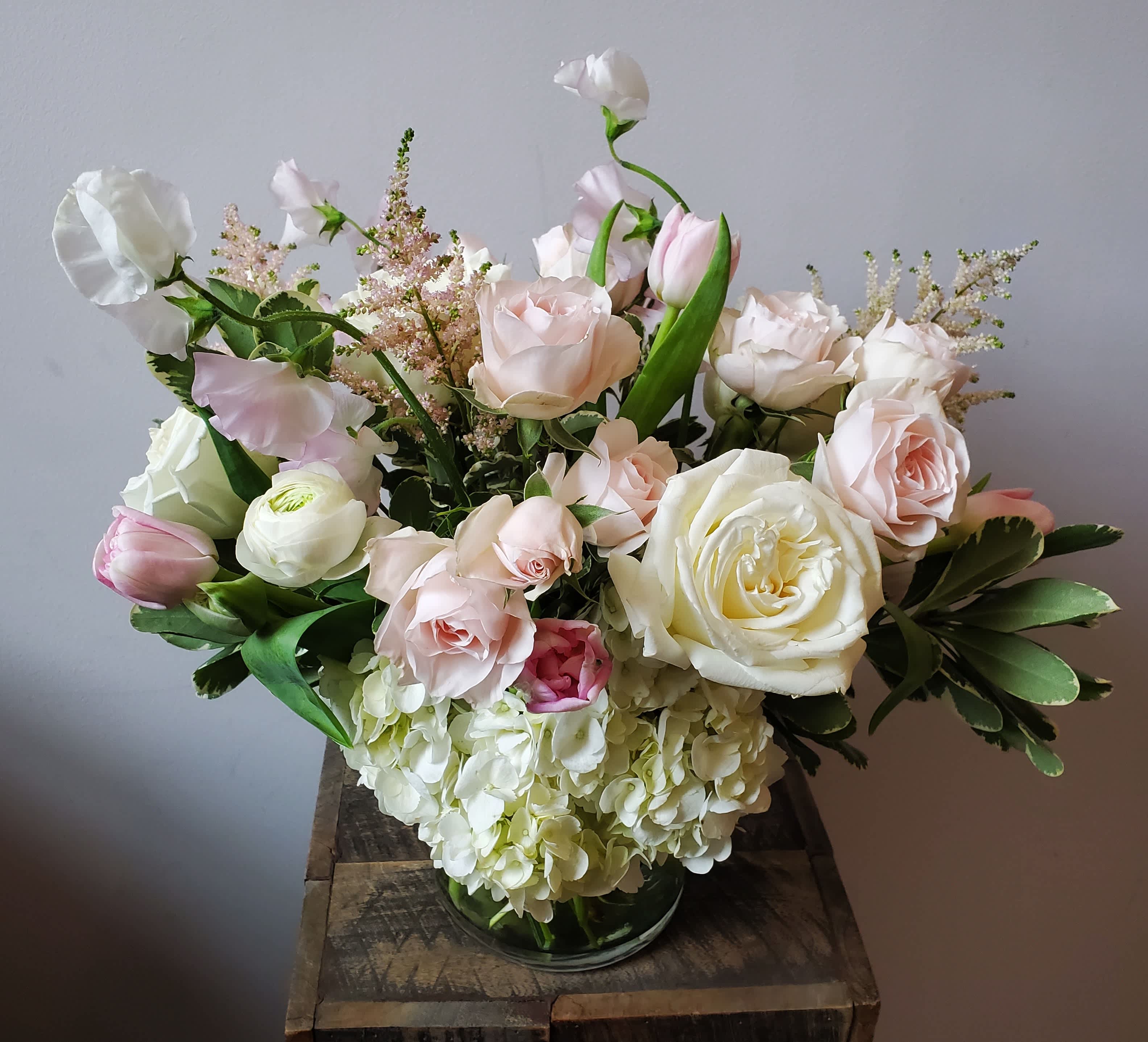 Old Fashioned Love Song - A classic spring garden-style arrangement featuring roses, astilbe and tulips in shades of white and soft blush pink.  Arrangement measures approximately 12x16".