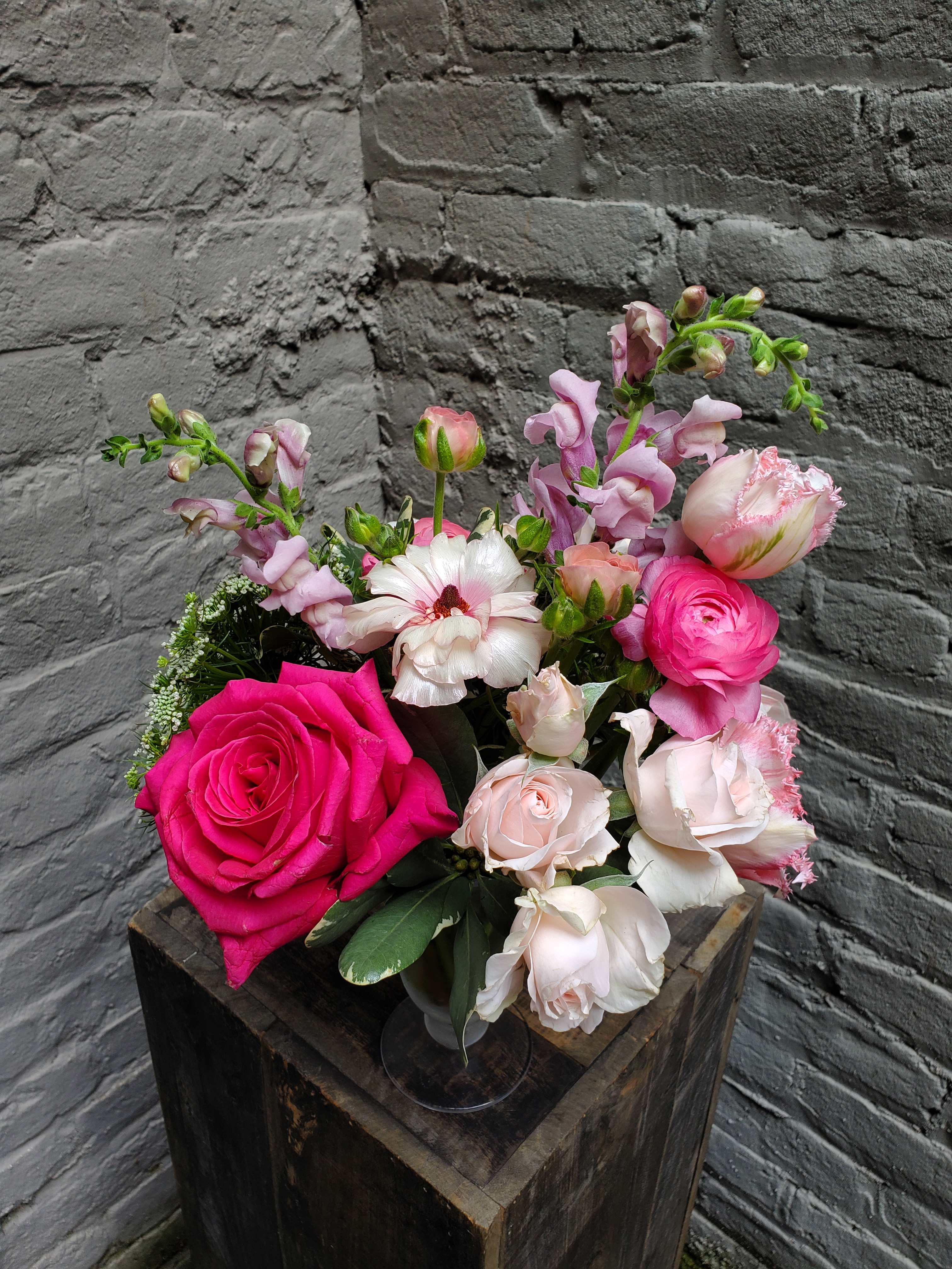 Raspberry Parfait - A sweet arrangement of all pinks in a parfait-style clear glass compote!  Fragrant roses, ranunculus, and Queen Anne's Lace.  Measures approximately 12" tall x 10" wide.