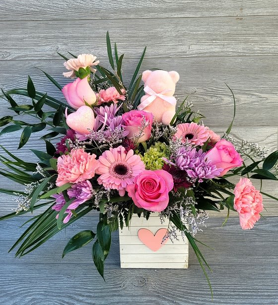 Pink Bear Bouquet - A beautiful assortment of pink, lavender, purple and green blooms arranged in our heart cube with a cute pink bear accent. Arrangement is one sided. 