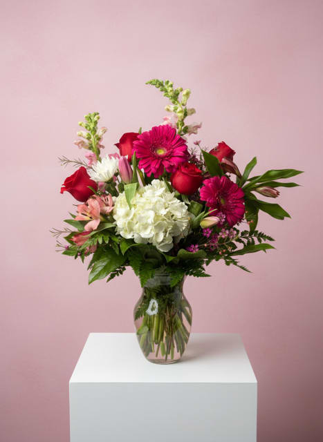 Love Always - Love Always is a timeless floral arrangement that speaks from the heart. Designed with a romantic blend of soft pinks, rich purples, and delicate textures, it features a graceful mix of roses, gerbera daisies, and snapdragons nestled in lush greenery. Elegant and heartfelt, Love Always is a beautiful expression of enduring affection—perfect for Valentine’s Day, anniversaries, or simply to remind someone they are always loved. 
