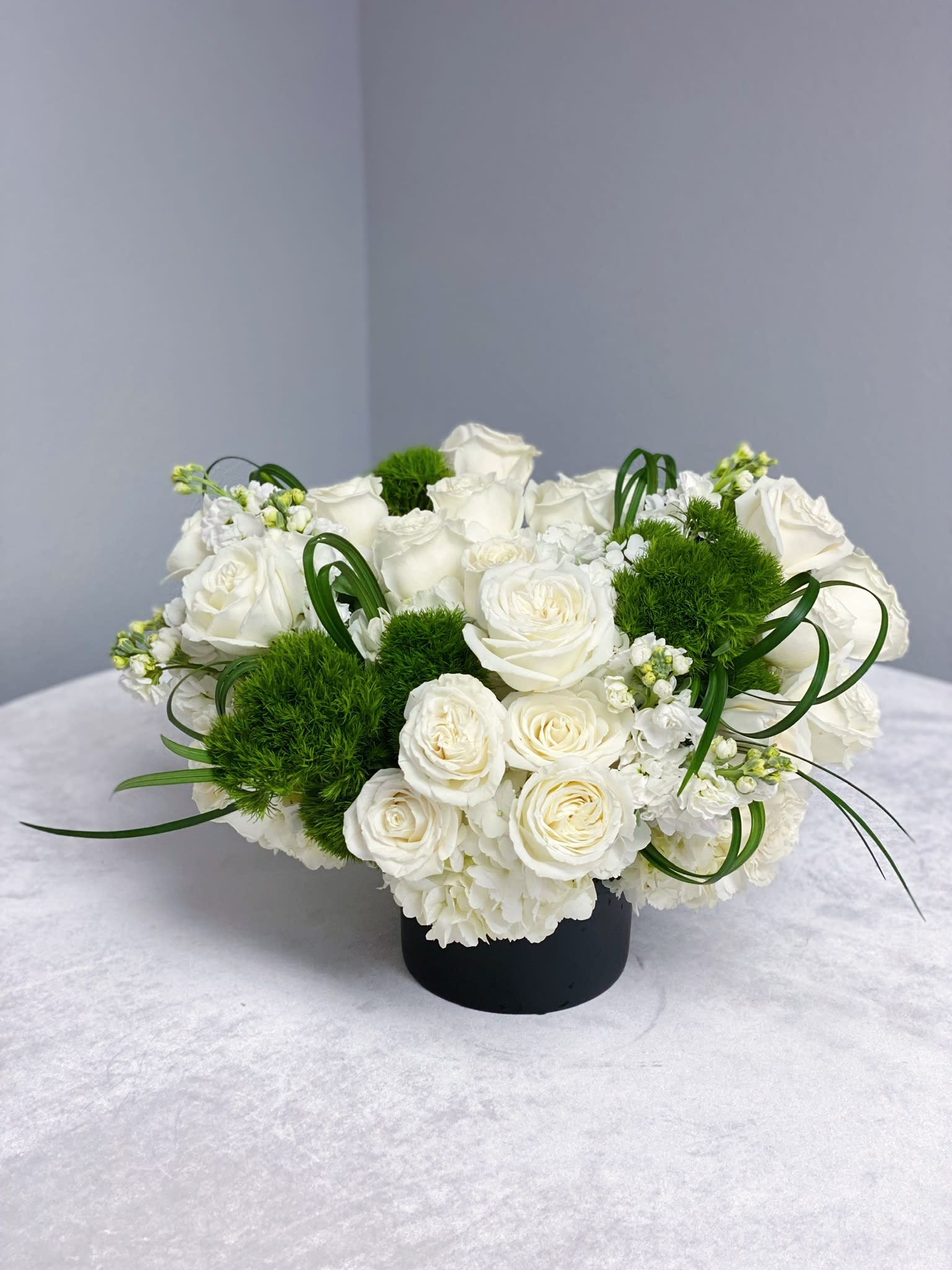 2 dosen white roses in a vase  - 2 dosen white roses in a vase with hydrangeas, dianthus, Lily grass and stock. 